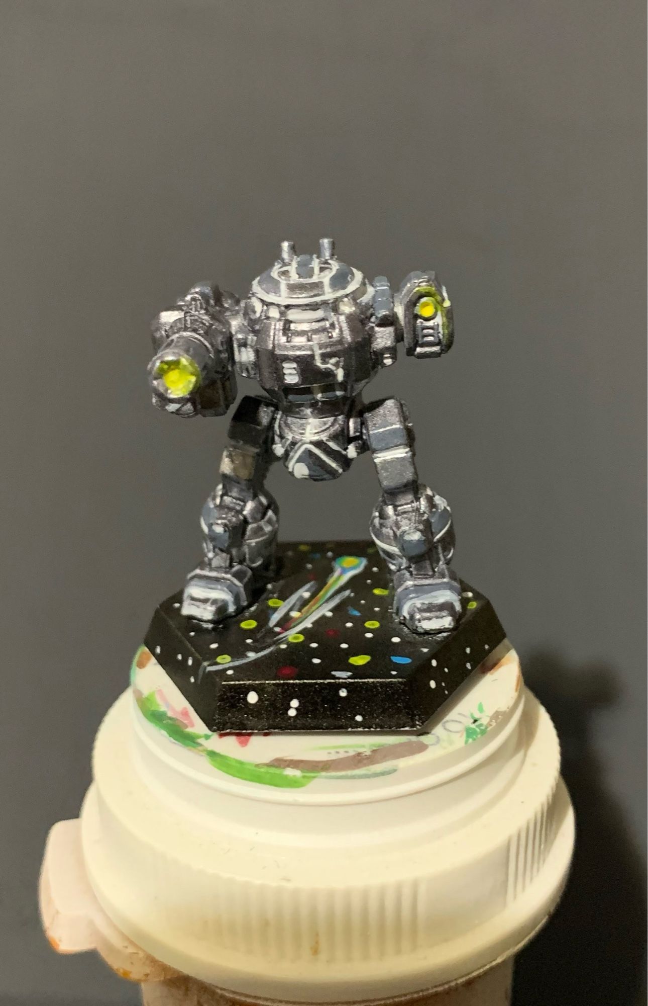 an Urban Mech in a Death Star paint scheme! It is facing forward with yellow highlights on the AC 10 and small laser! it has a starry base featuring a comet and constellations!