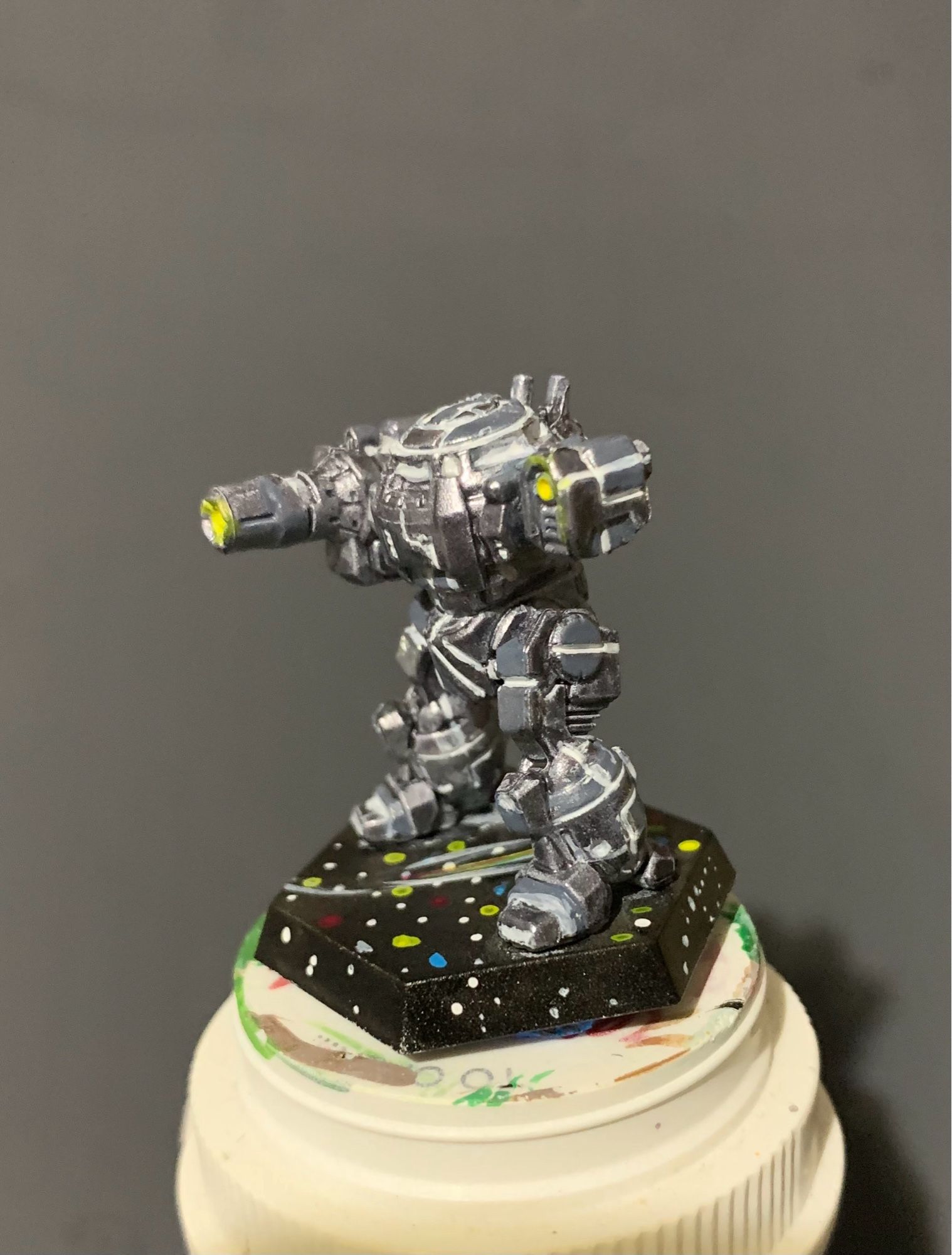 an Urban Mech in a Death Star paint scheme! It is facing right with yellow highlights on the AC 10 and small laser! it has a starry base featuring a comet and constellations!