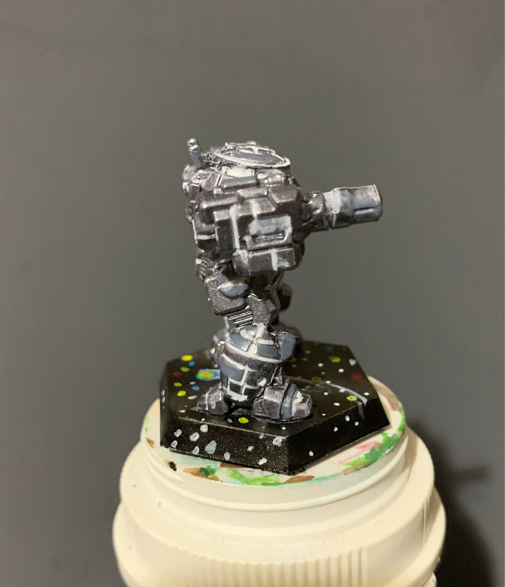 an Urban Mech in a Death Star paint scheme! It is facing left with yellow highlights on the AC 10 and small laser! it has a starry base featuring a comet and constellations!