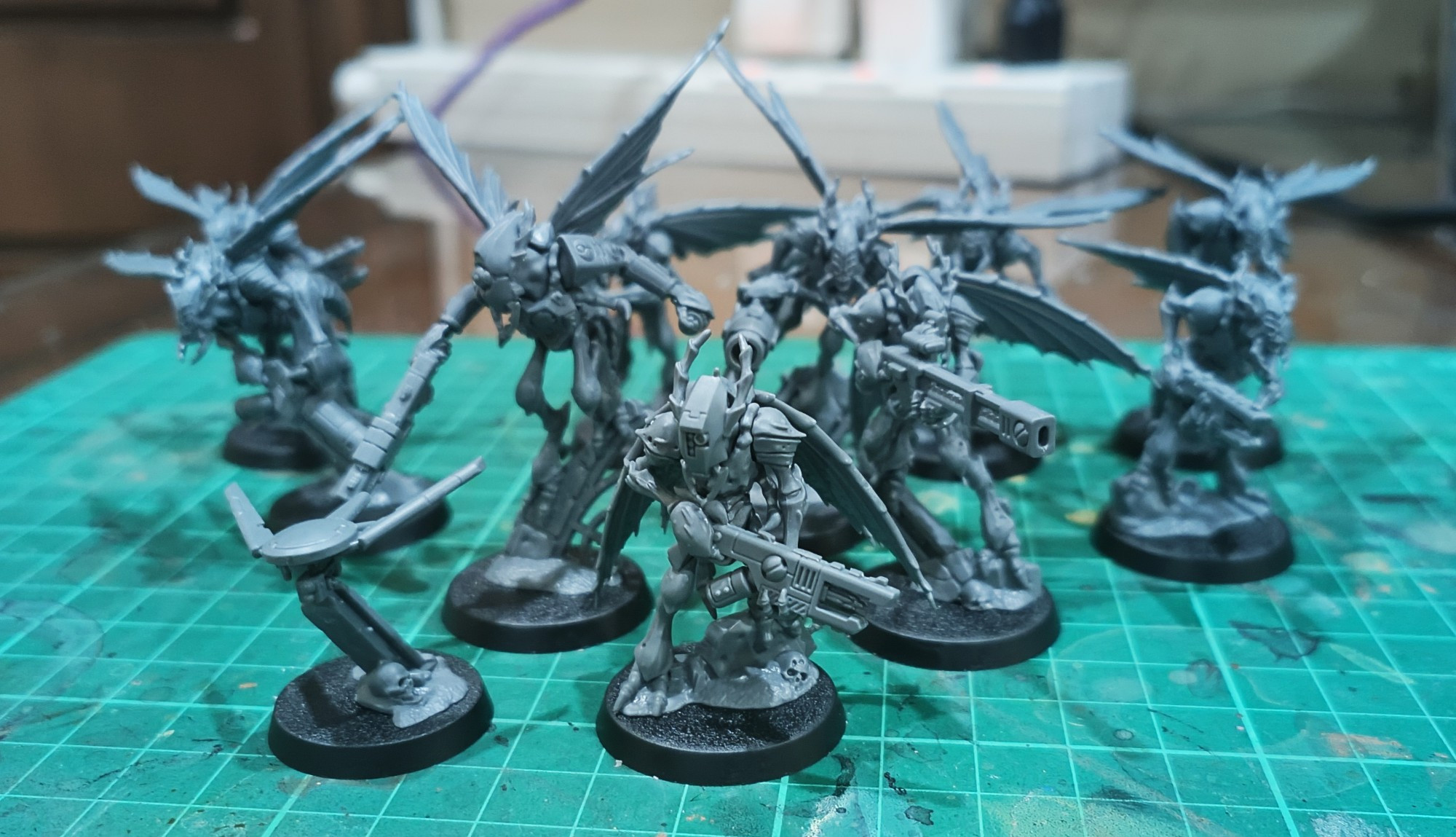 Unpainted miniatures of insect-like humanoids with futuristic weapons