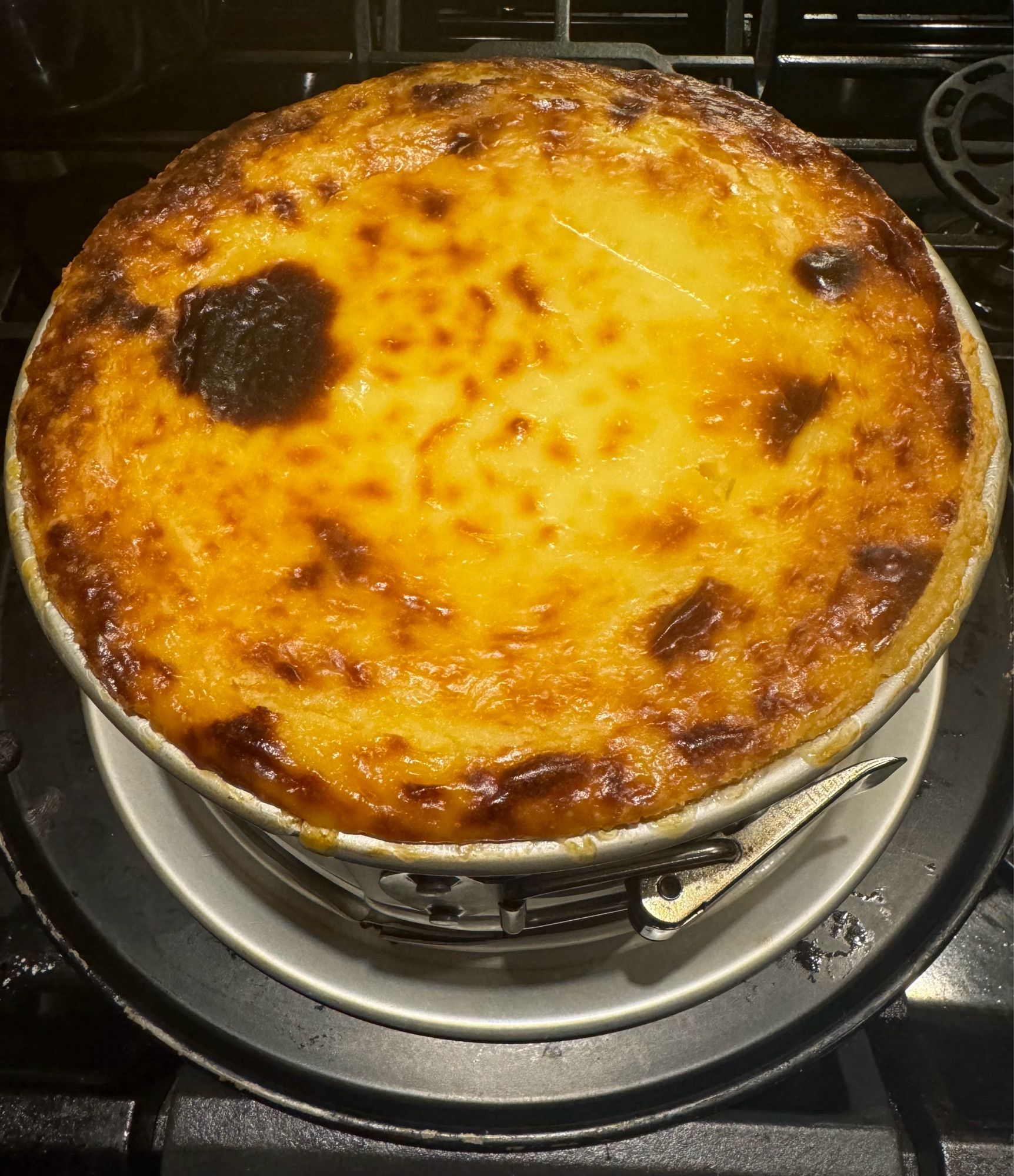 Golden brown souffled cheesecake on a stove.