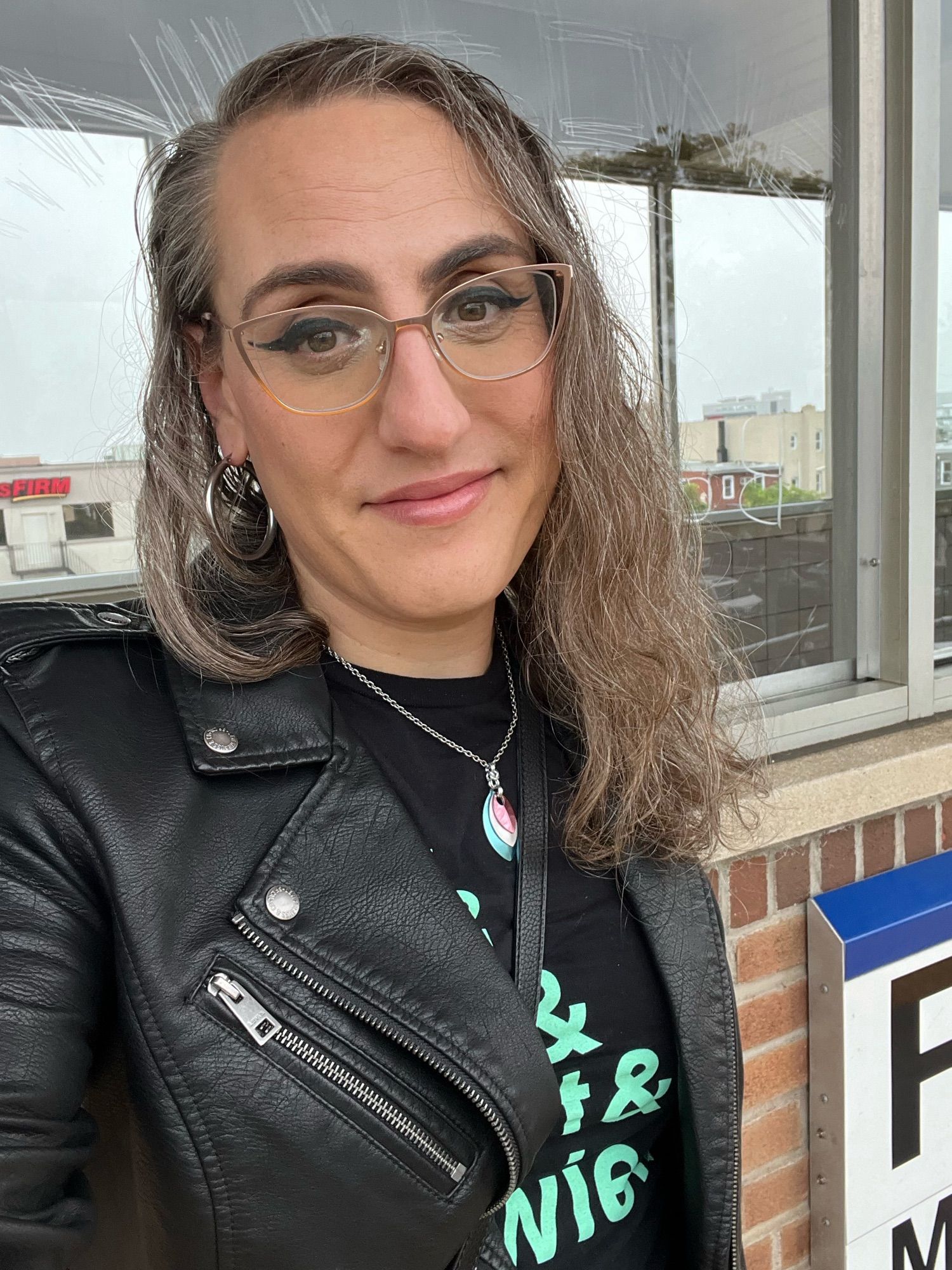 Me, Dawn, on an LIRR platform wearing a NY Liberty shirt and a leather jacket