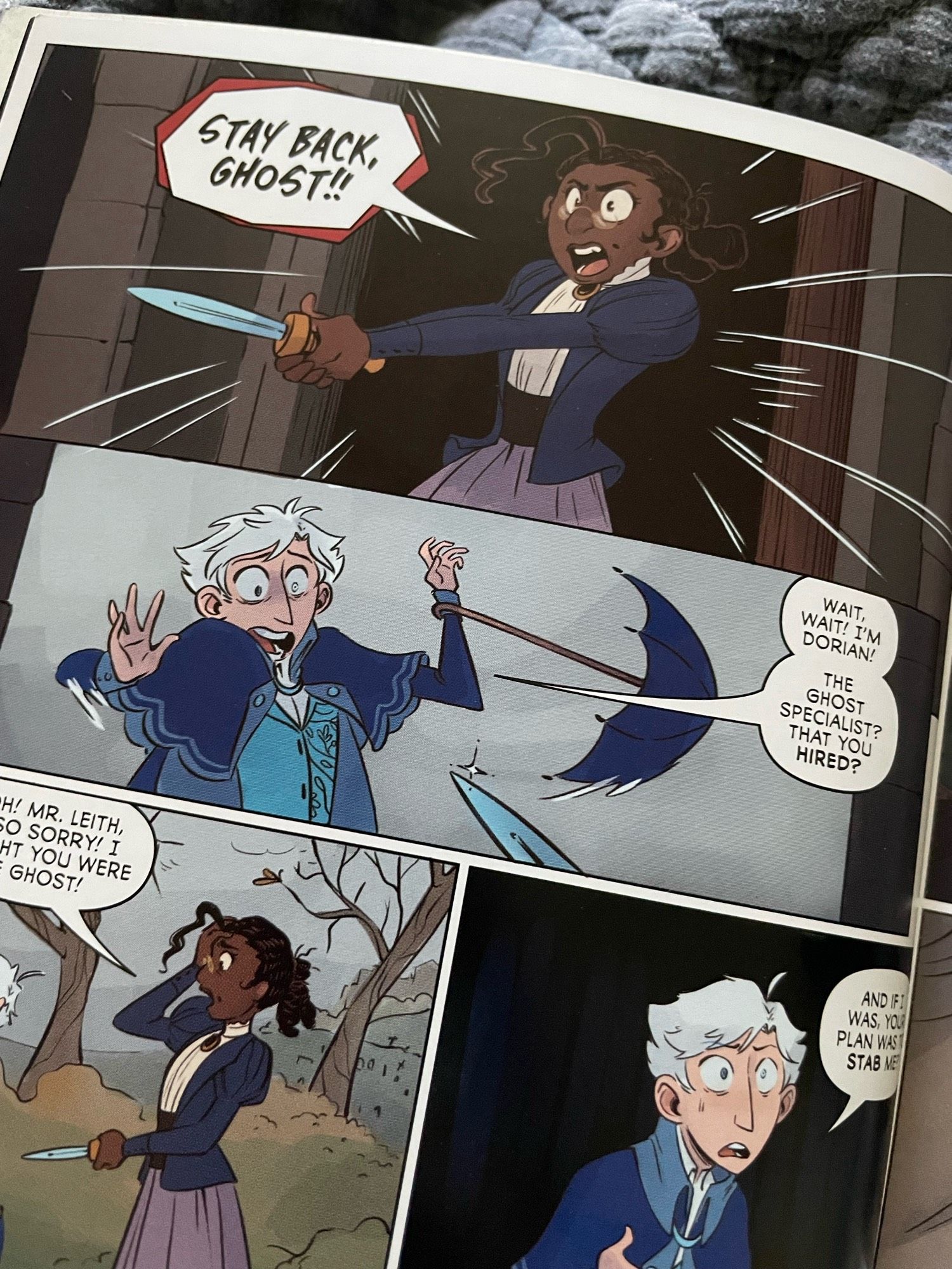 A young black woman in Victorian dress and glasses brandished a knife and yells in a panic, “Stay back, Ghost!” A young pale man with white hair and one ghostly blue eye drops his fussy umbrella and cries, “Wait! I’m Dorian! The ghost specialist? That you HIRED?”