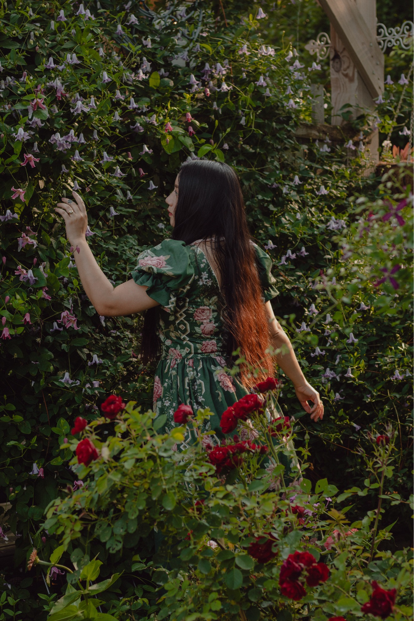 A girl surrounded by flowers at a garden.