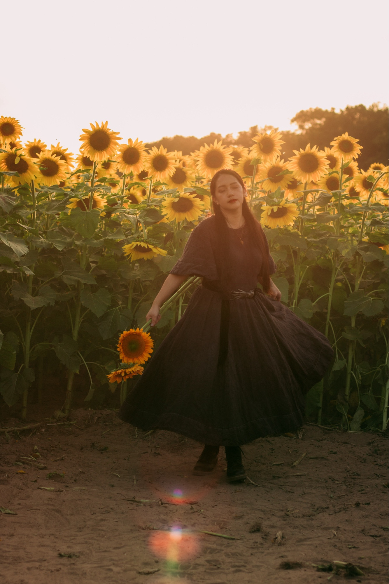 A girl twirling during golden hour at the sunflower farm.