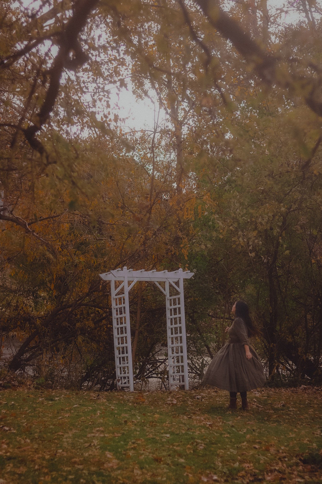 A girl, surrounded by fall. She’s turning around to look at the fall foliage.