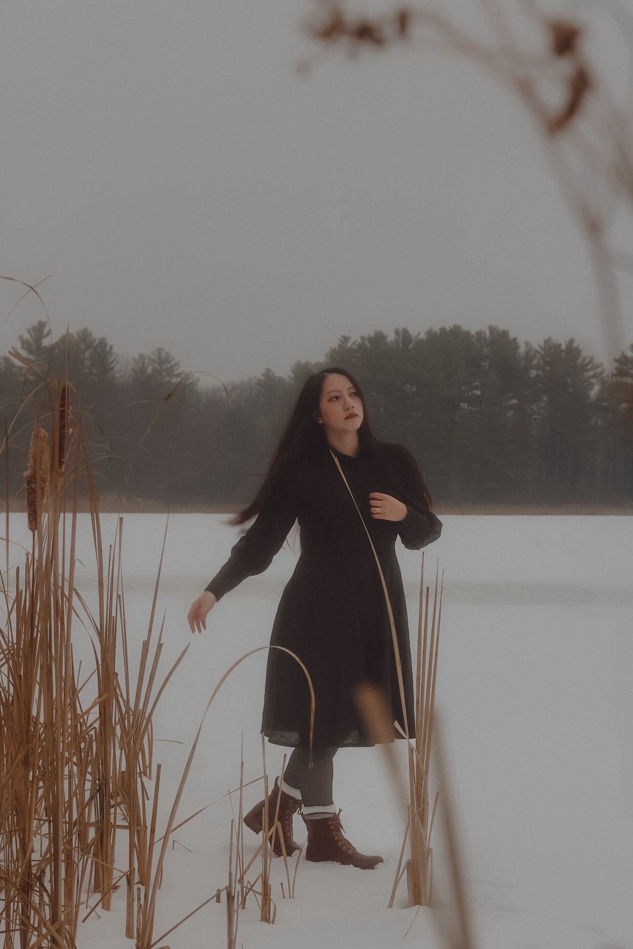 A girl in a black dress, moving on a snowy frozen lake.