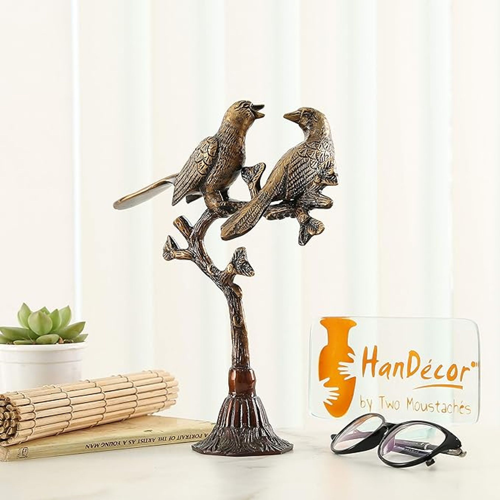 About this item
Product Weight : 1.05 Kg
Dimensions: Length: 8 inches (20 cm), Width: 3 inches (7.5 cm), Height: 9 inches (22.5 cm)
Package Contains: 1 Unit Of Love Birds on Tree Brass Showpiece
Luxurious Quality: Crafted from premium brass, our showpiece exudes opulence, promising a lasting impression that radiates elegance.
Heartfelt Gift: The lovebirds on this tree sculpture symbolize eternal love, making it an ideal gift for weddings, anniversaries, or romantic occasions.
Description 
Embellish your living space with the beguiling style of Two Mustaches Metal People in love on Tree Show-stopper. This perfect home stylistic layout piece includes unpredictably created metal people in love roosted on a tree limb, representing never-ending adoration and congruity. Remaining at 9 inches tall and weighing 1.05 kg, this colorful work of art adds a hint of refinement to any room. Wonderful as a focal point or emphasize piece, enjoy the immortal excellence of this puppet and raise your home