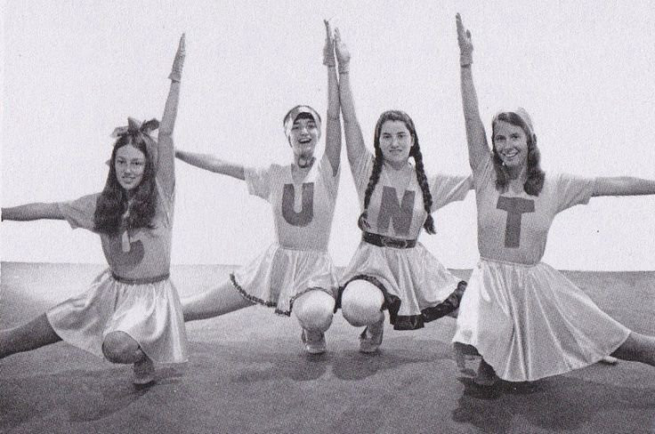 Four cheerleaders, each wearing a sweater with a different letter on it: a ‘C’, a ‘U’, an ‘N’ and a ‘T’.