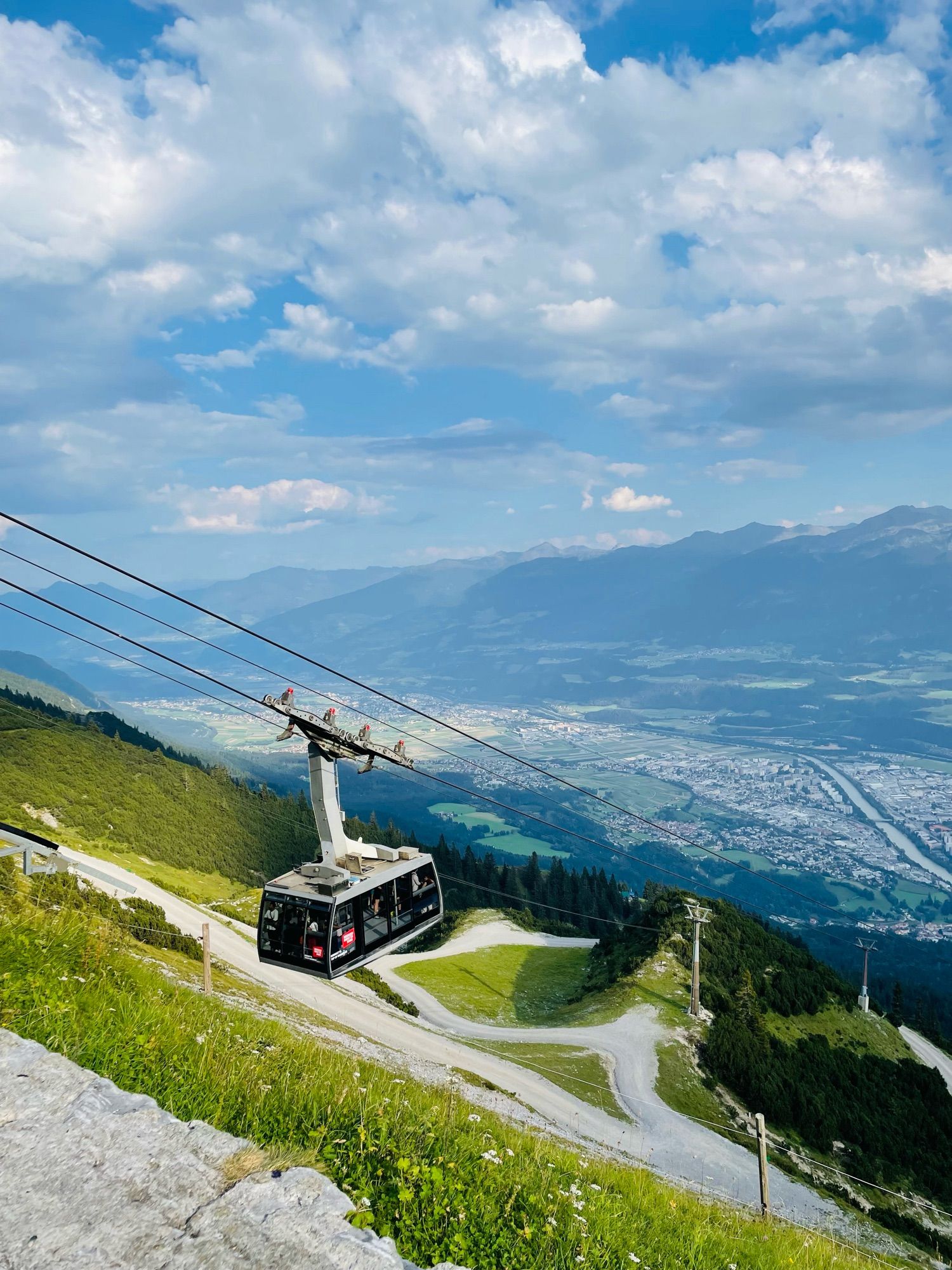 Cable car making its way up the mountain with the city below.