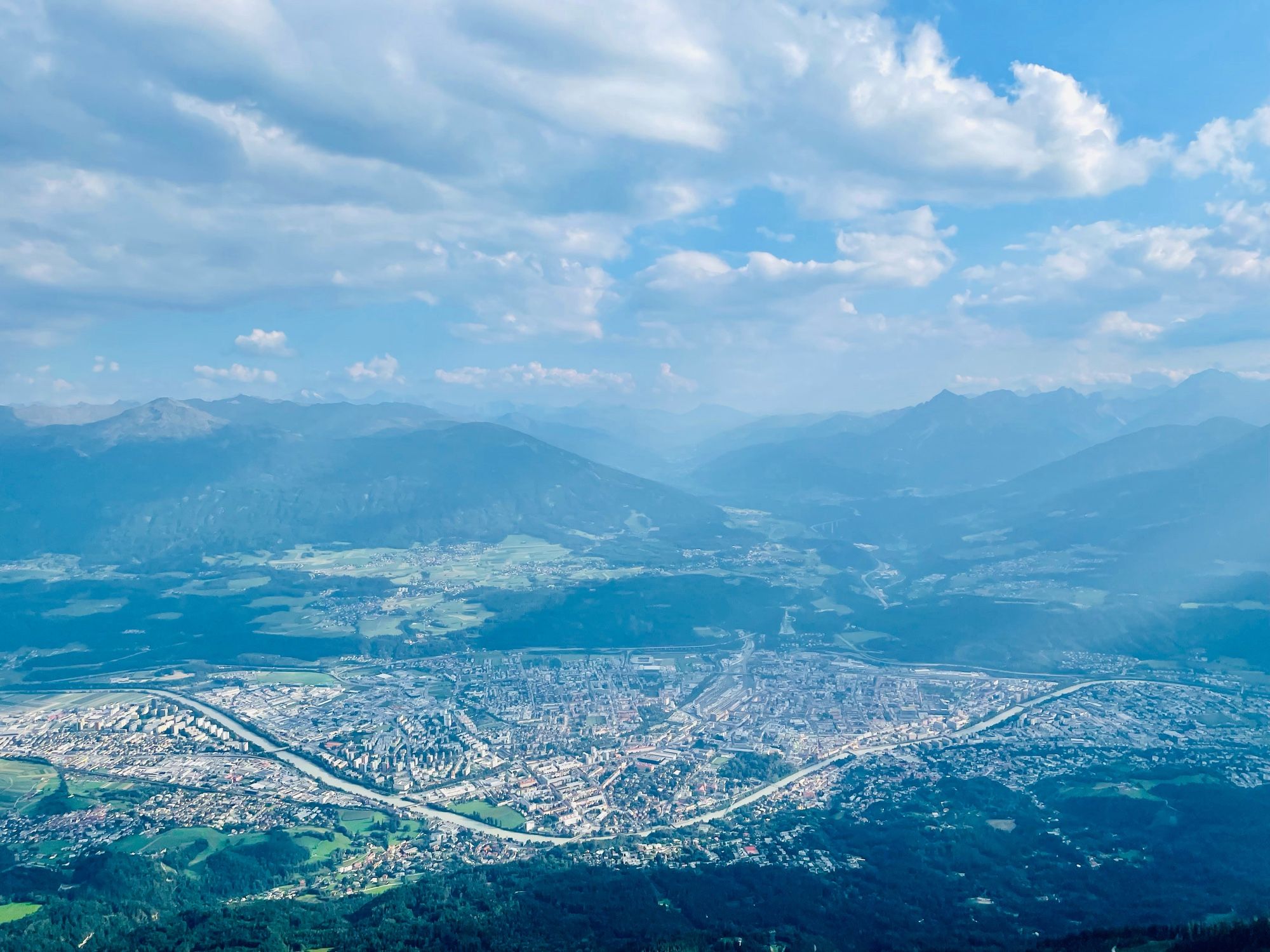 View of the mountain peaks and scenery of Innsbruck down below in the distance.