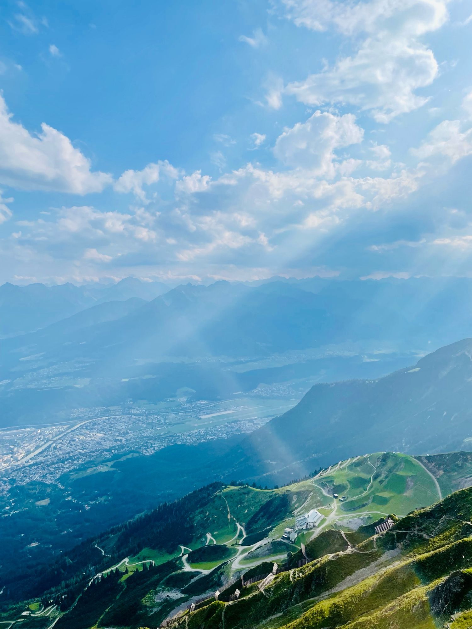 View of the mountain peaks and scenery of Innsbruck down below in the distance.