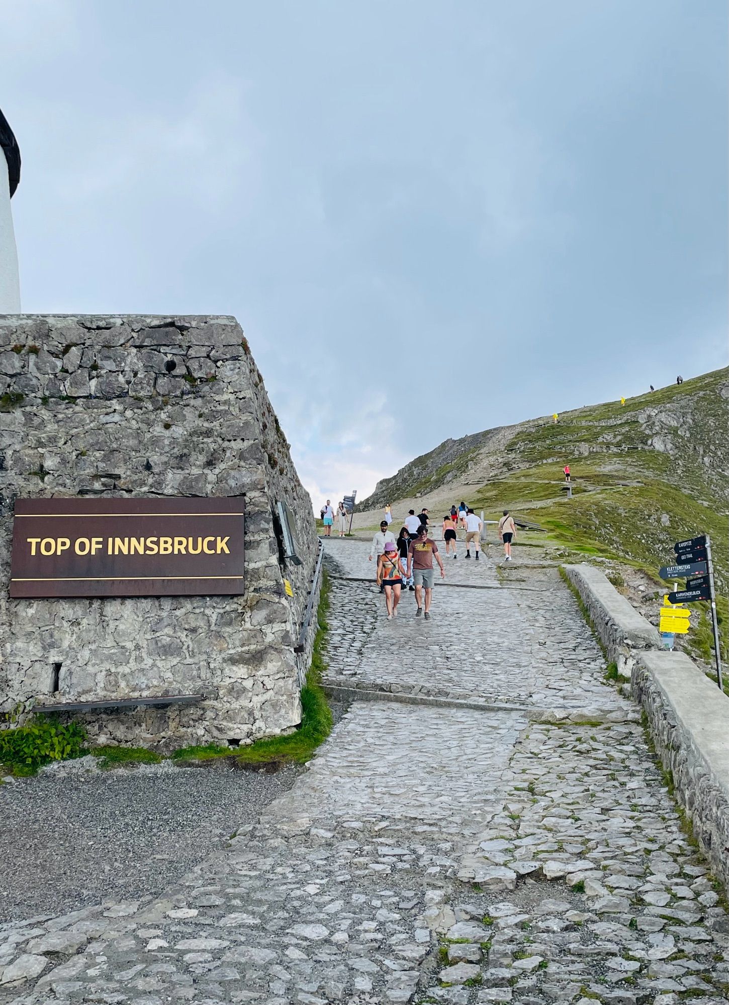 “Top of Innsbruck” sign. Winding paved walkway leads up to the top of the mountain.