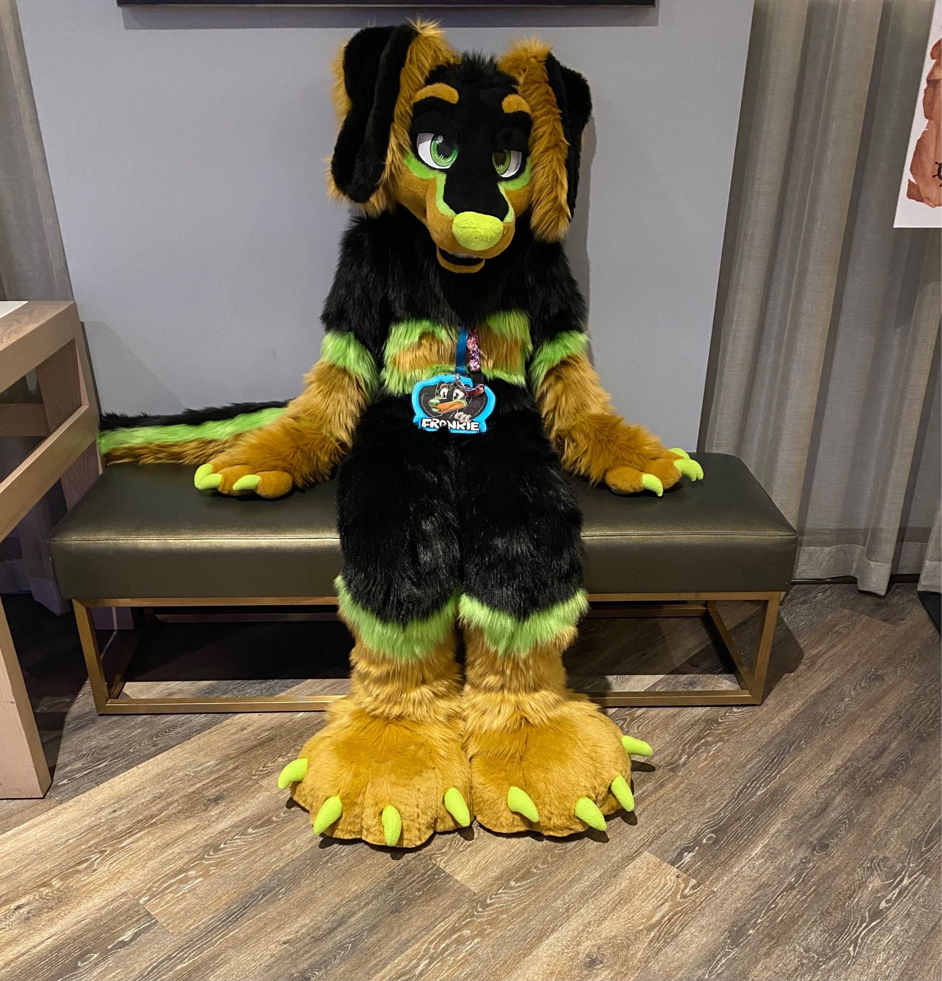 Dachshund fursuiter sitting on a bench in a hotel lobby