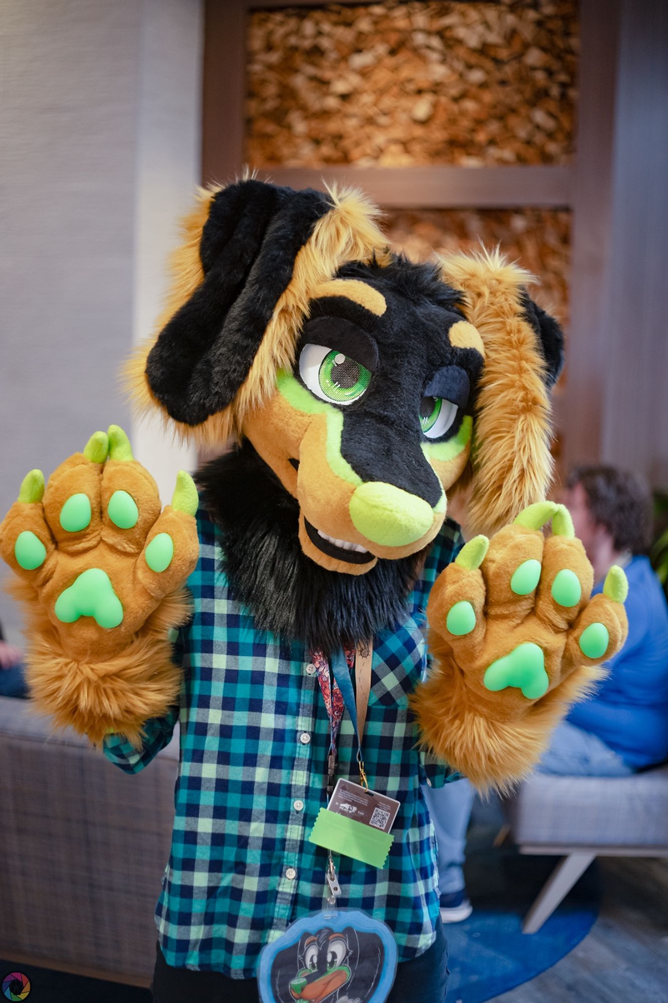 dachshund fursuiter standing in a hotel lobby, waving to the camera with both paws