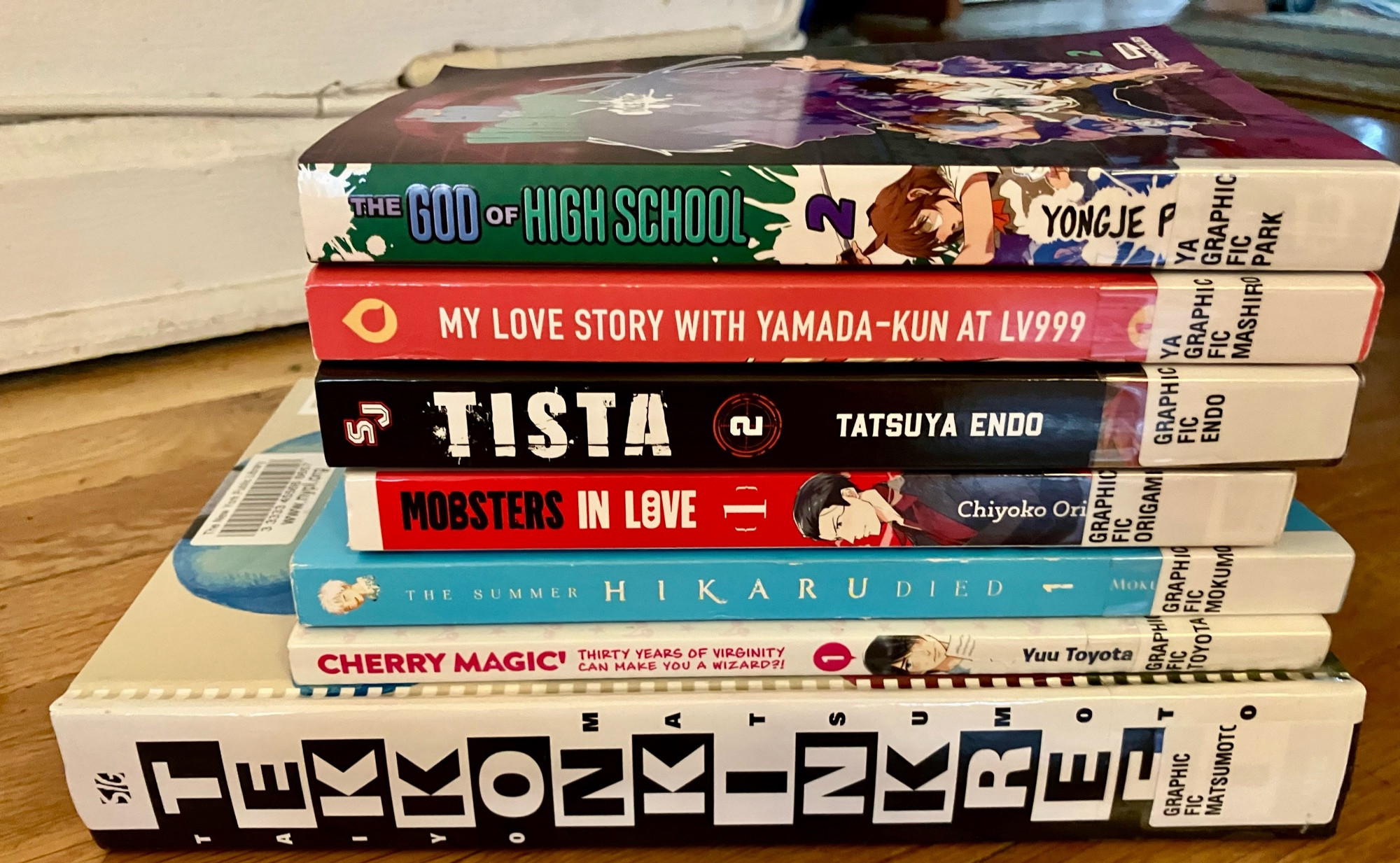 Stack of books. The God of High School 2, My Love Story with Yamada-kun at Lv999 1, Tista 2, Mobsters in Love 1, The Summer Hikaru Died 1, Cherry Magic Thirty Years of Virginity Can Make You a Wizard 1, Tekkonkinkreet