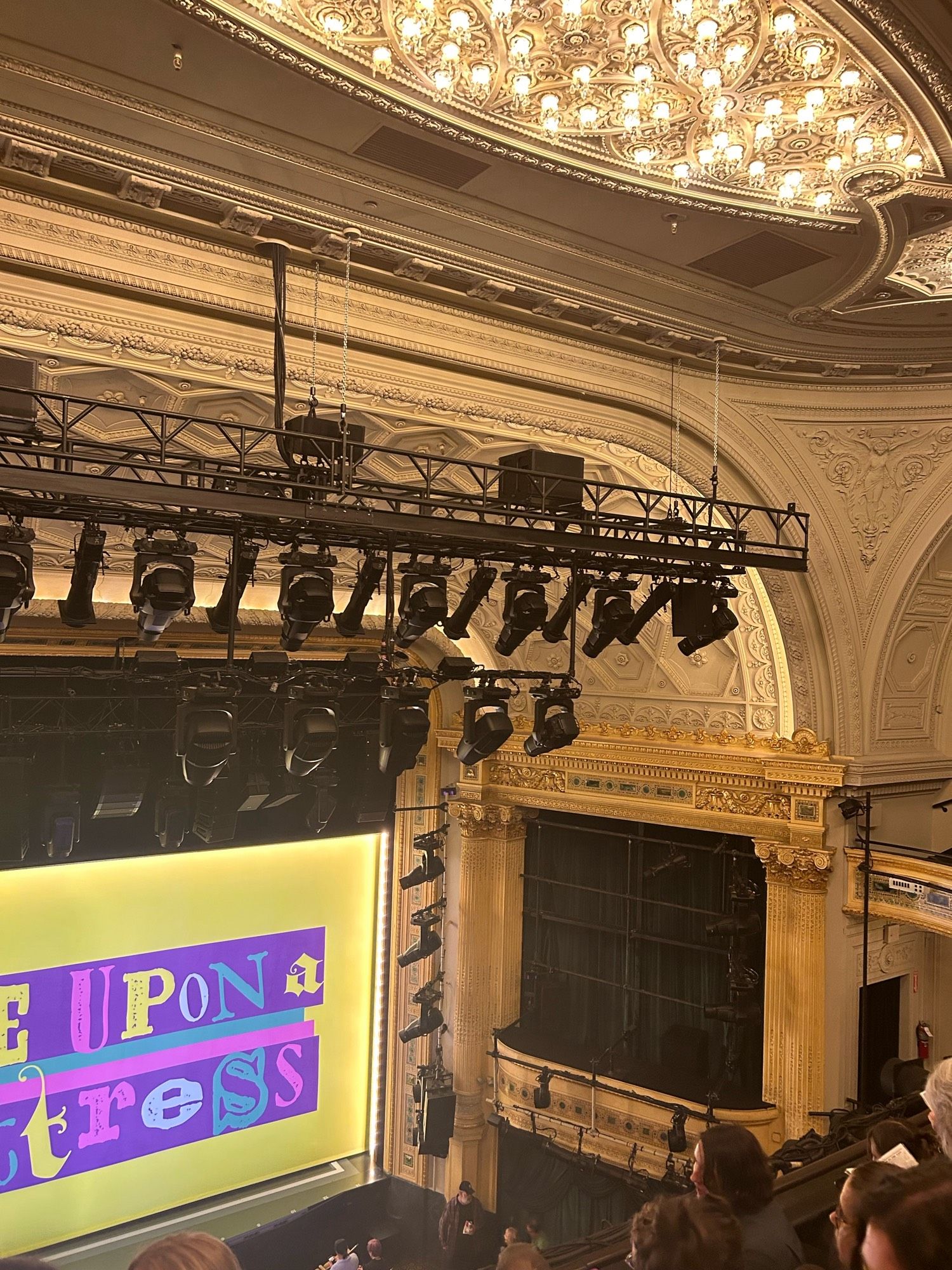 Ceiling and arch of Hudson Theatre, featuring molding, relief carvings, tiled edges, and miniature chandeliers in series