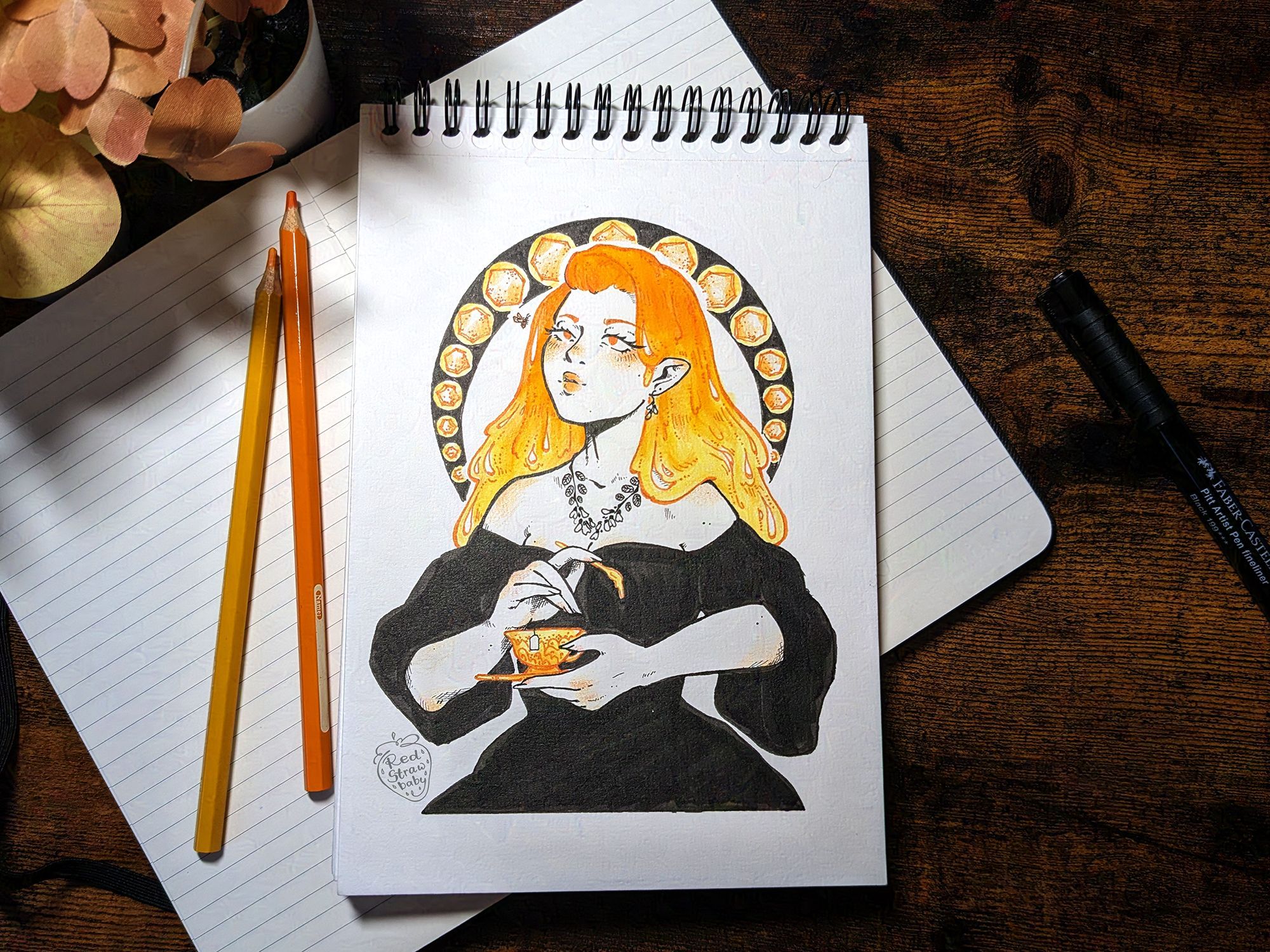 A photo of an aesthetic table lay with yellow and orange pencils and notebooks, the focus of the picture being a spiral sketchbook with an illustration of a woman in it. She is wearing a black dress and has long flowing honey hair, her eyes are a little crossed as she looks at a little bee close to her face. She's holding a tea cup and a spoon with honey dripping from it.