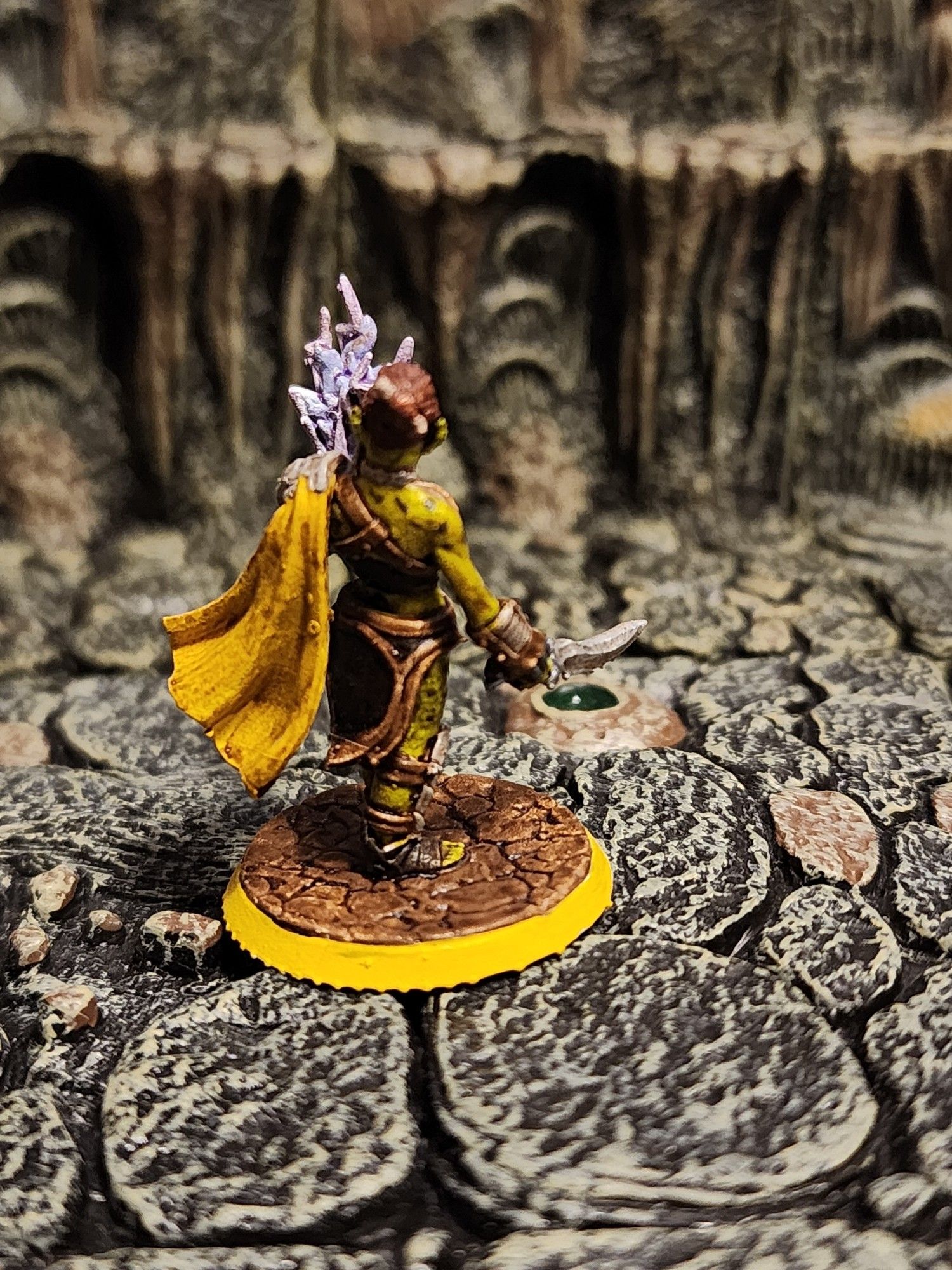 A backview of the Githyanki woman, showing some more detail about her leather armor, as well as her silver pauldron and yellow half cape.