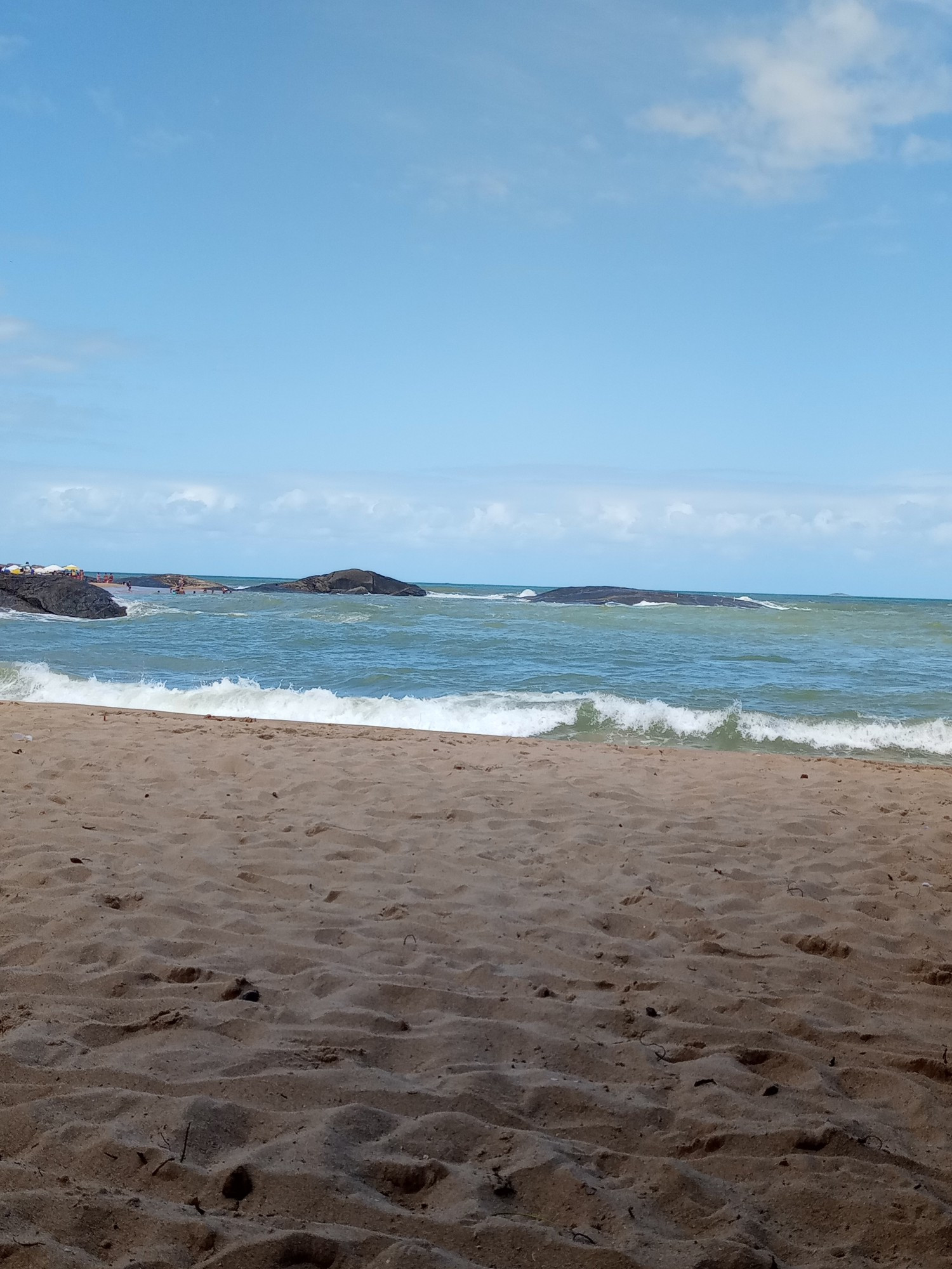 Faixa de areia com ondas do mar à frente