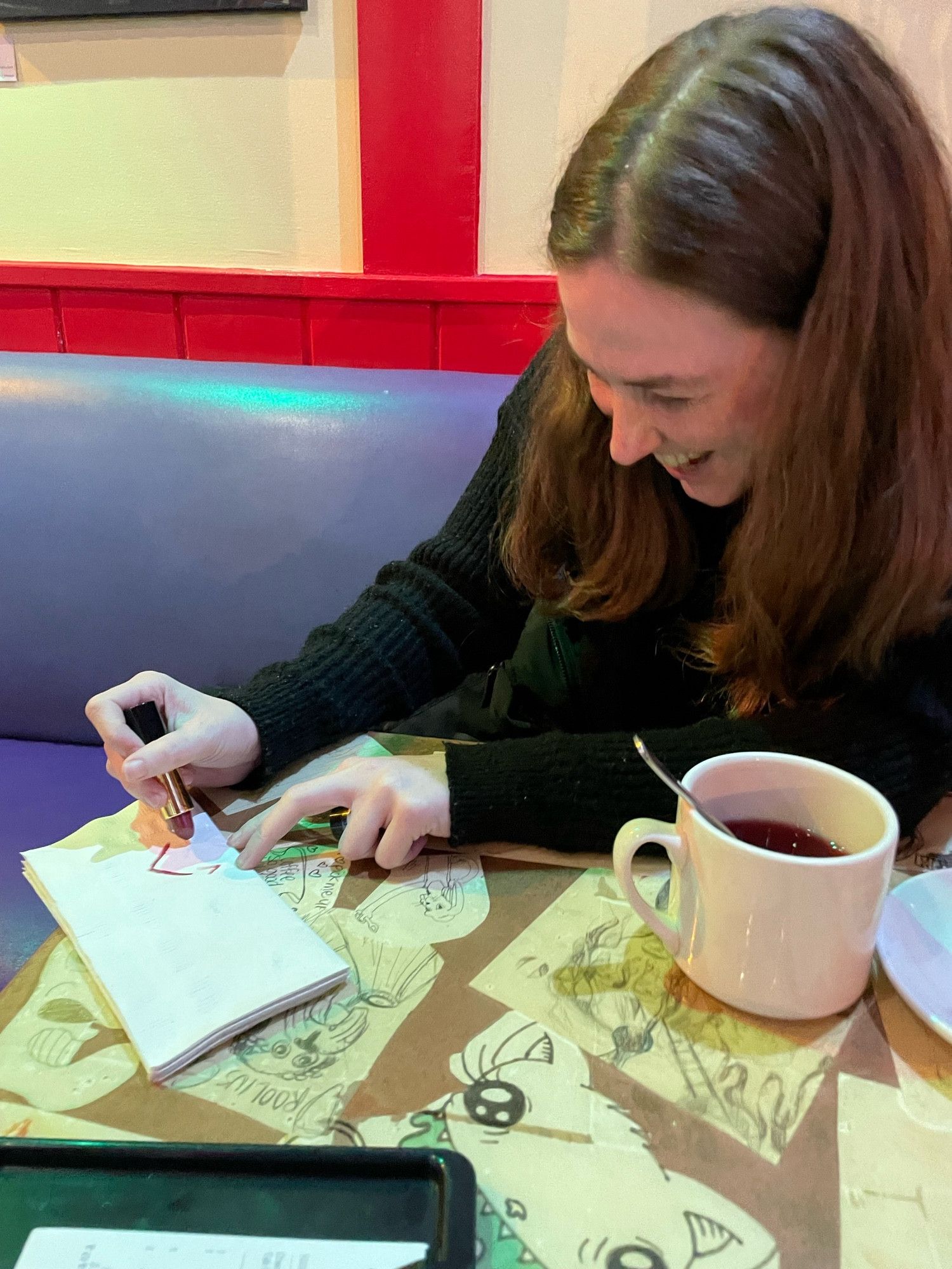 A woman drawing a diagram on a napkin with lipstick