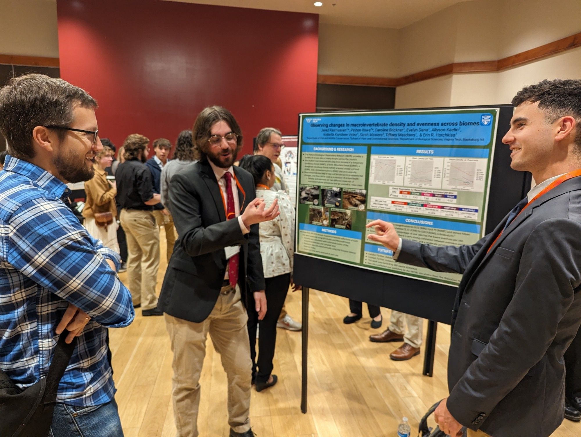 Two men describing the size of their favorite aquatic macroinvertebrates at a poster presentation