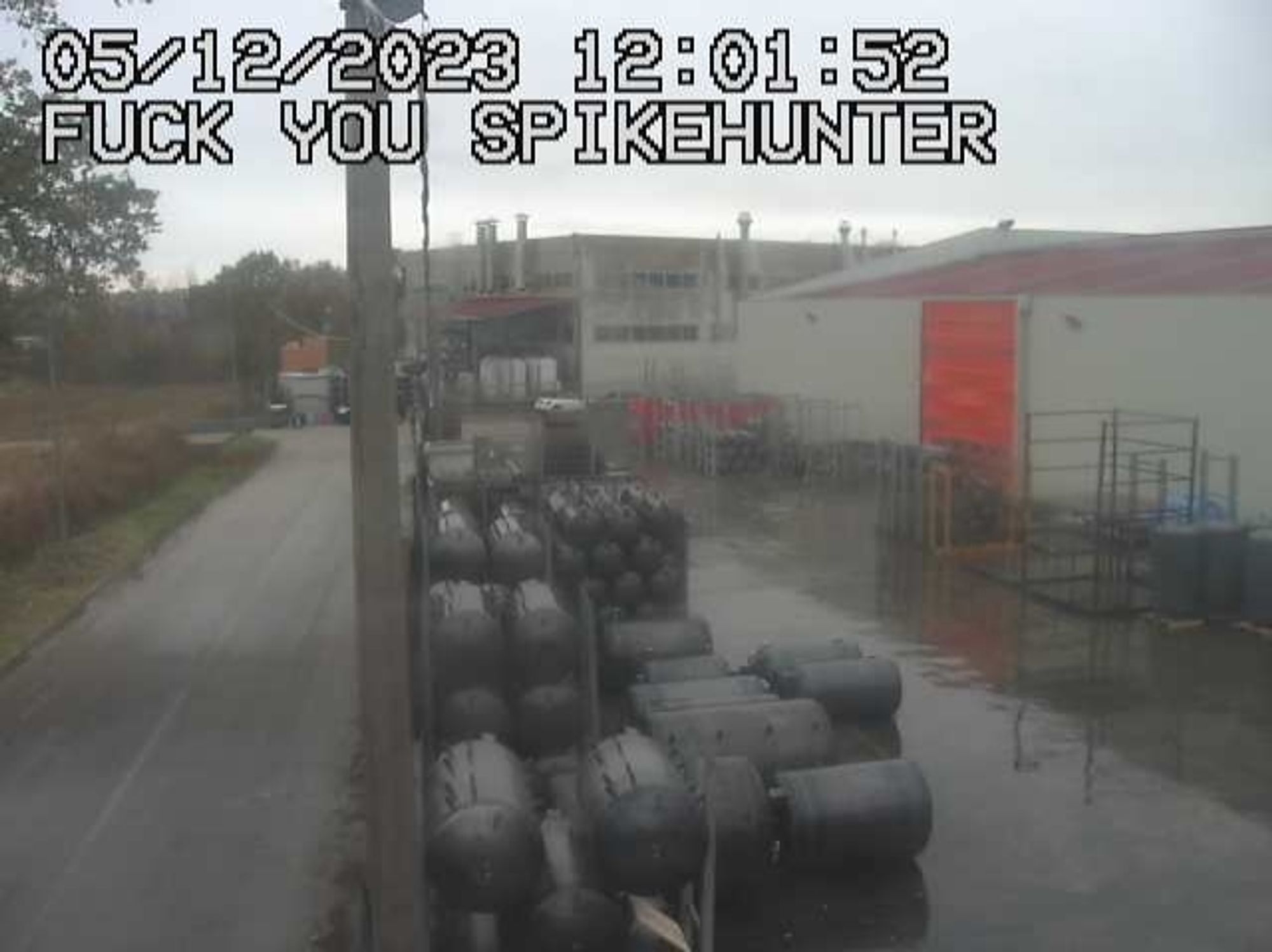 hacked cctv still shot of a factory displaying the text "FUCK YOU SPIKEHUNTER"