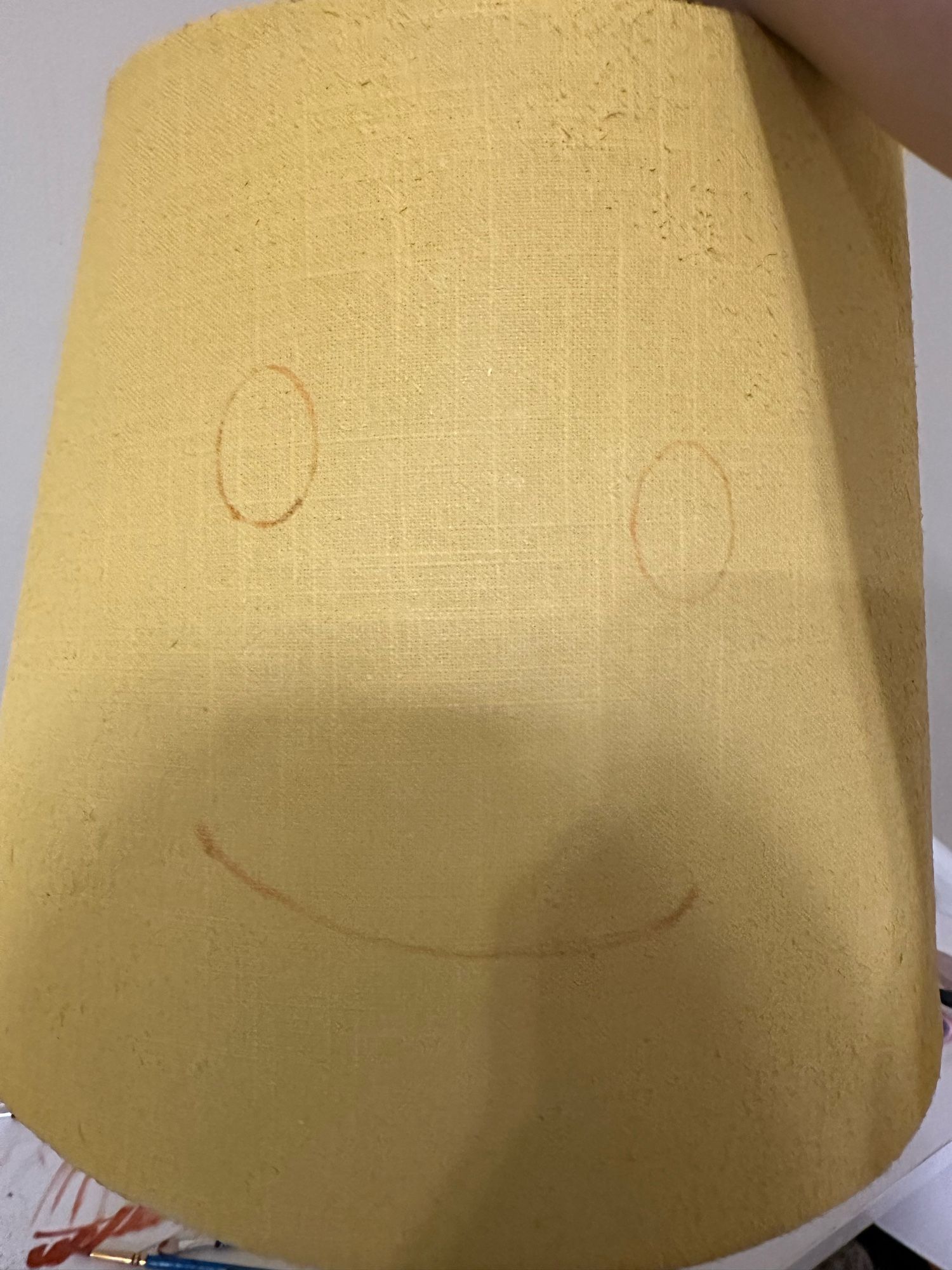 yellow lampshade with a smile sketched onto it