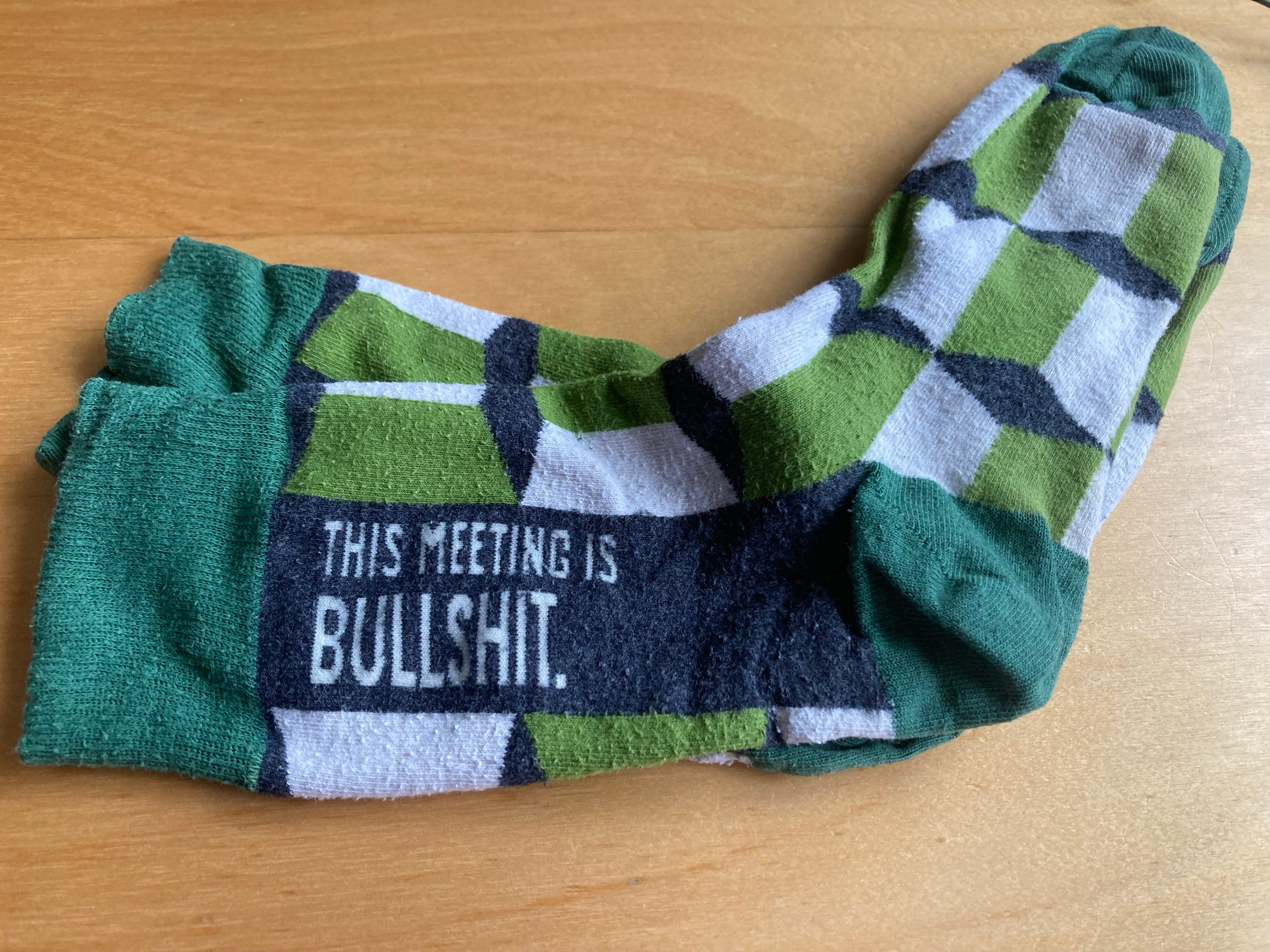 Green and white socks, with a grey area stating in white: THIS MEETING IS BULLSHIT.