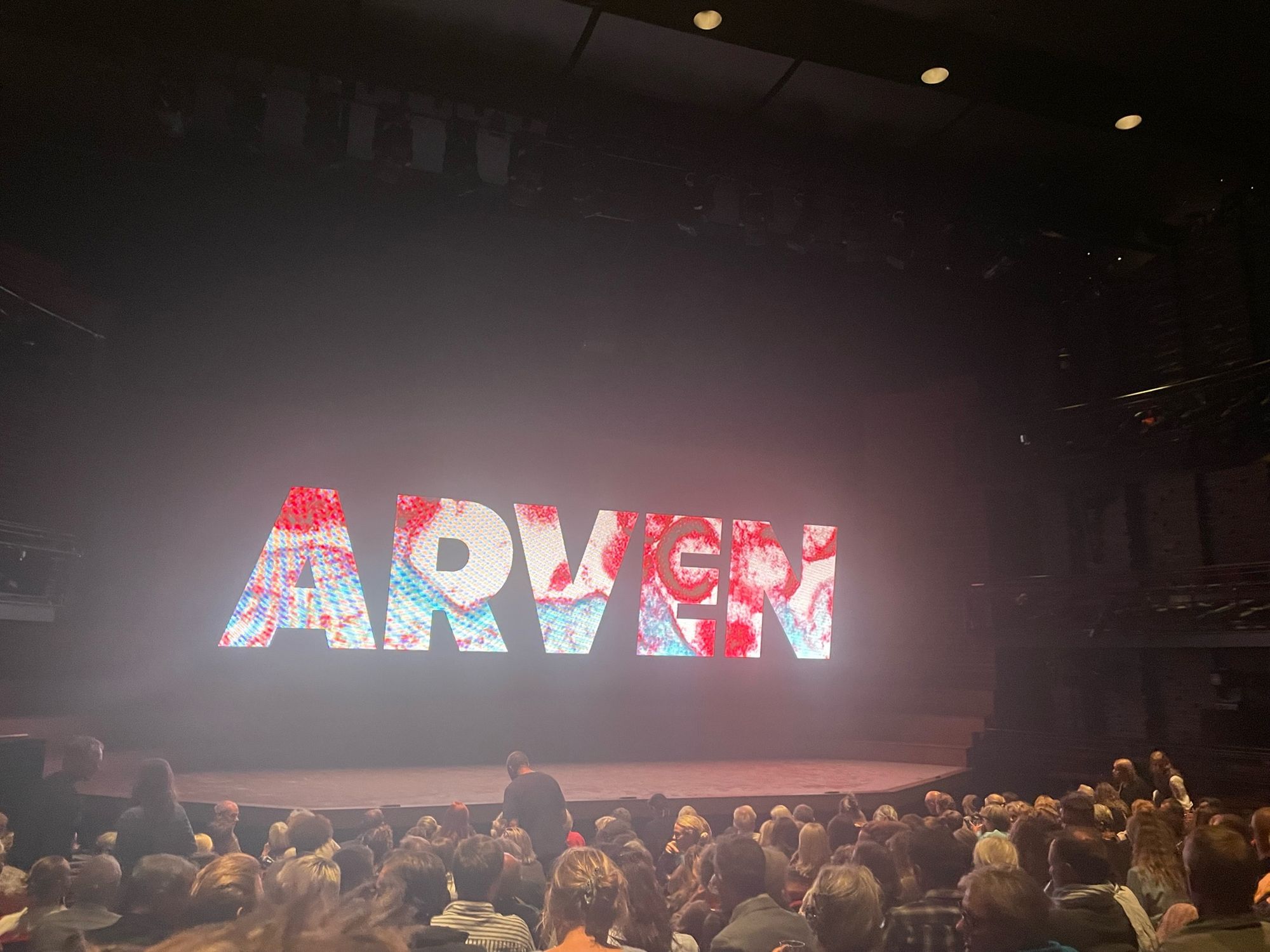 Picture of the stage at the Royal Danish Theatre’s playhouse with the Danish word Arven meaning The Inheritance displays on a large screen.