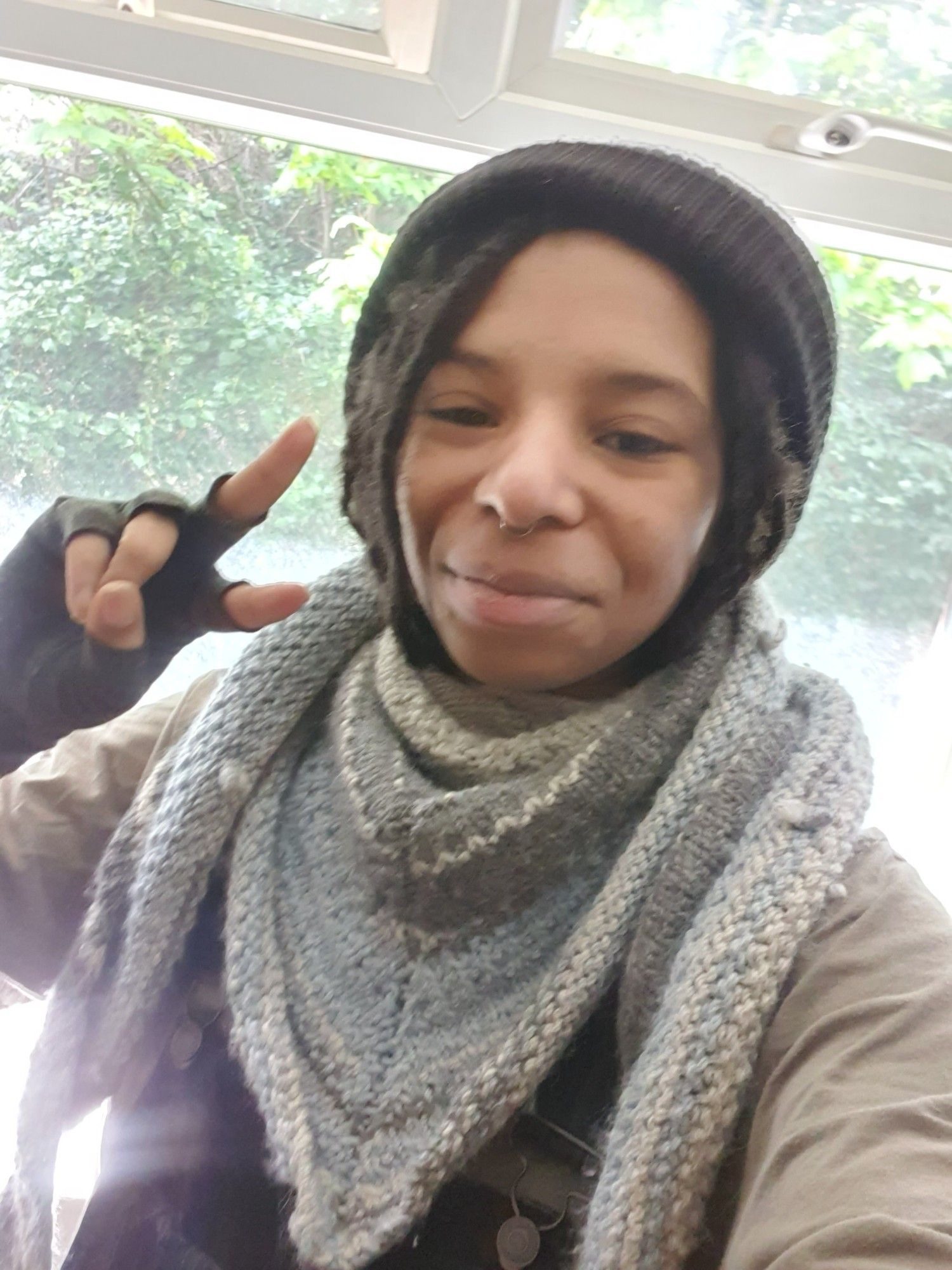 Another close up selfie with me wearing my  black beanie and doing a peace symbol with my hand. This time I am wearing my blue/grey shawl bandana style.