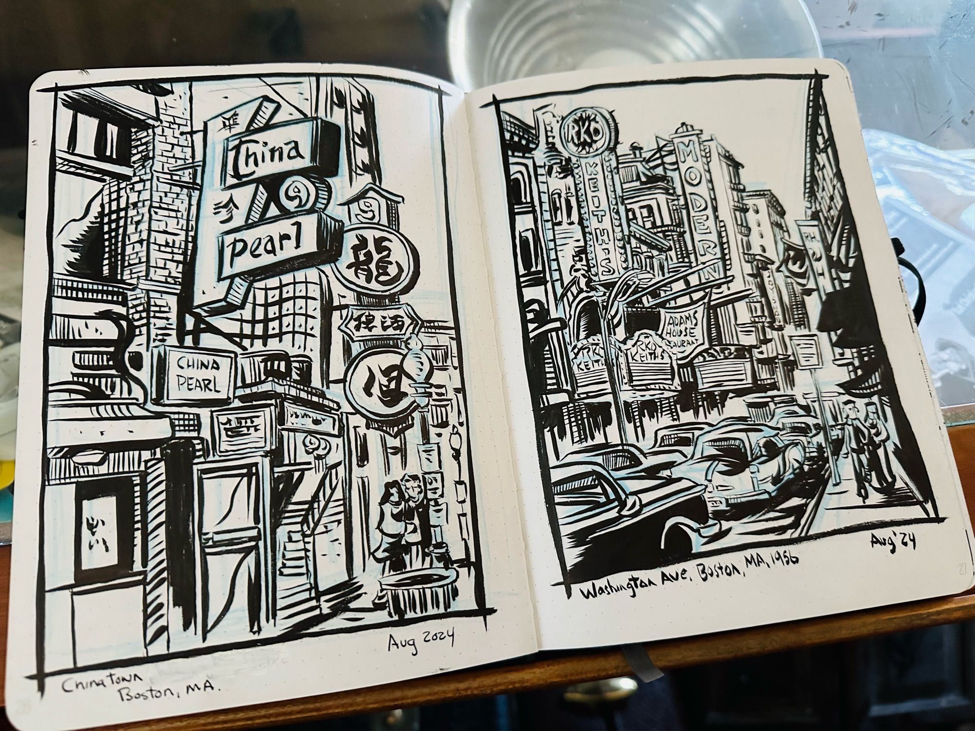 An open sketchbook on a drawing table with two black and white illustrations of Boston based on old photos.