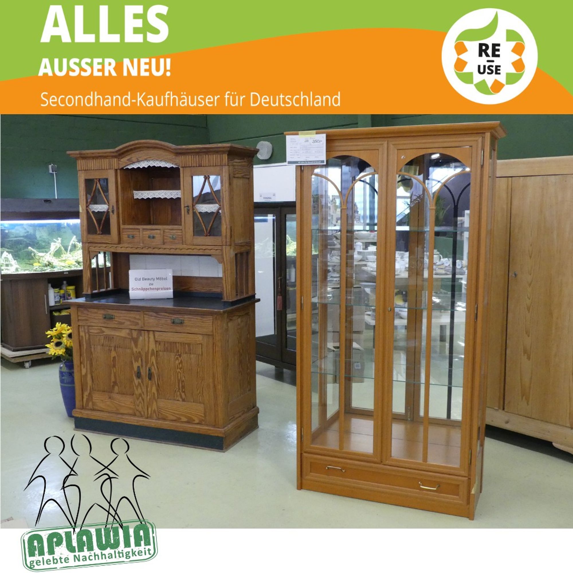 Eine Kirschholz-Glasvitrine und ein antikes Küchenbuffet im Vordergrund, ein Glasschrank, ein 60er Jahre Weichholzschrank und das zu APLAWIA gehörende Kaufhaus-Fischaquarium zieren den Hintergrund.