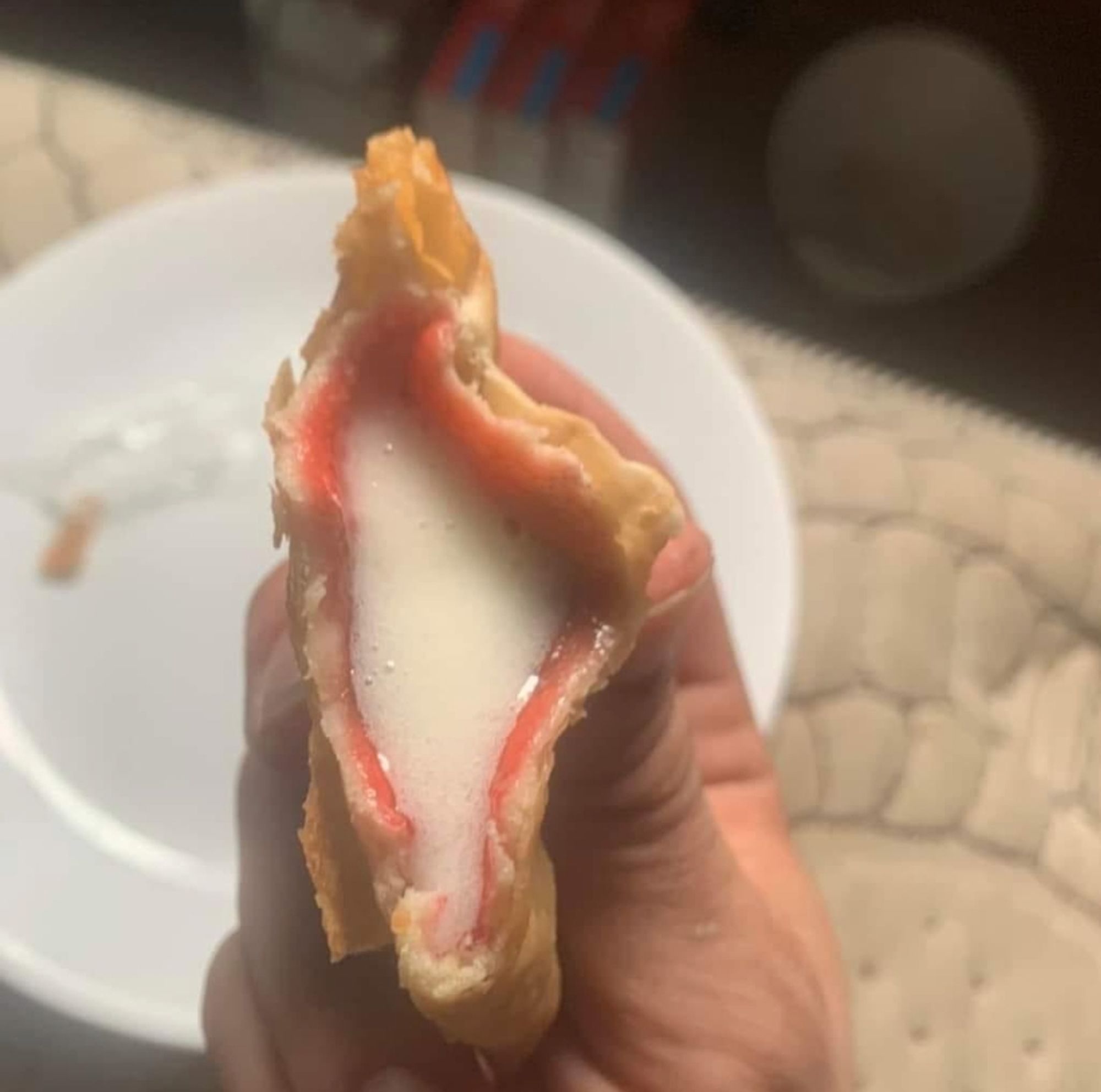 Toaster strudel with icing inside the filling pocket, a white plate in background