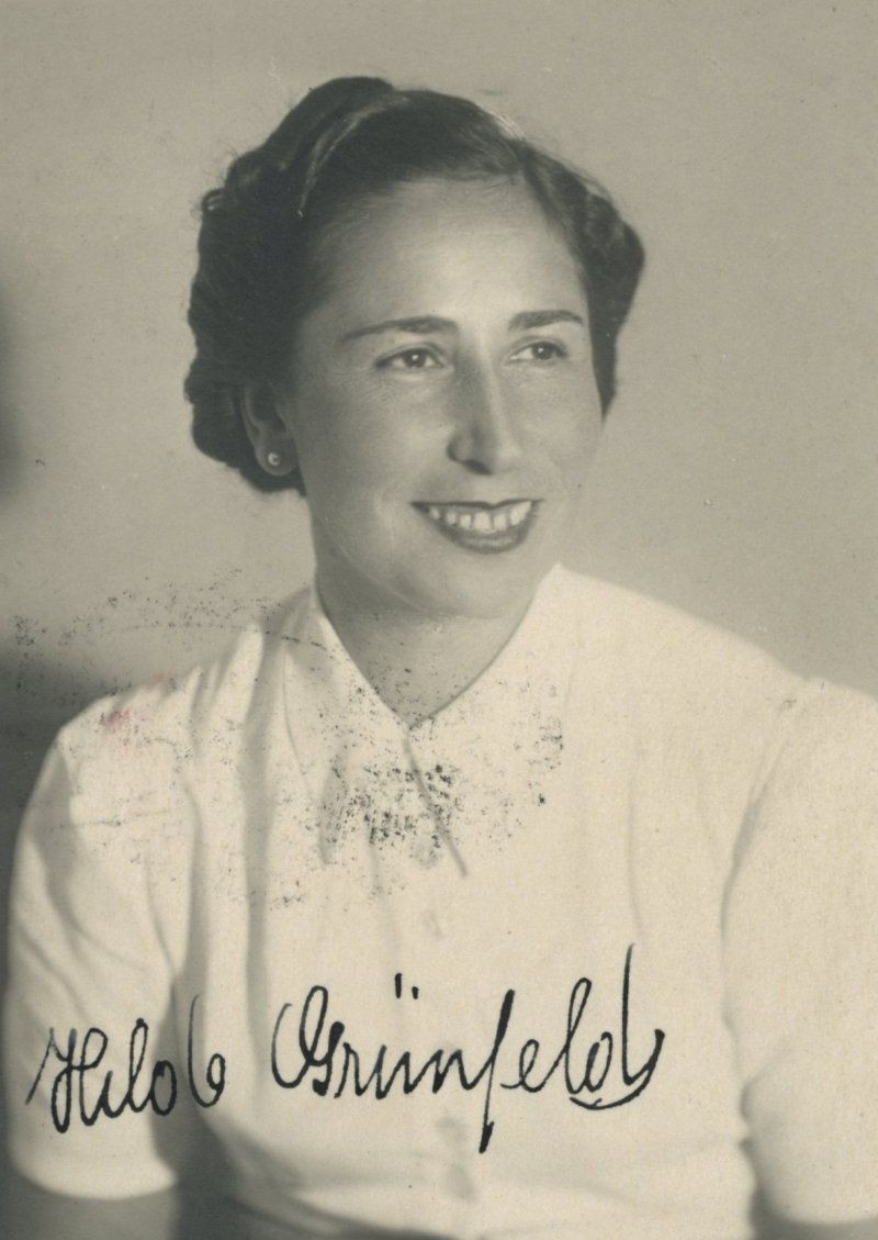 Vintage black and white photo of a woman, smiling and dressed in a light blouse