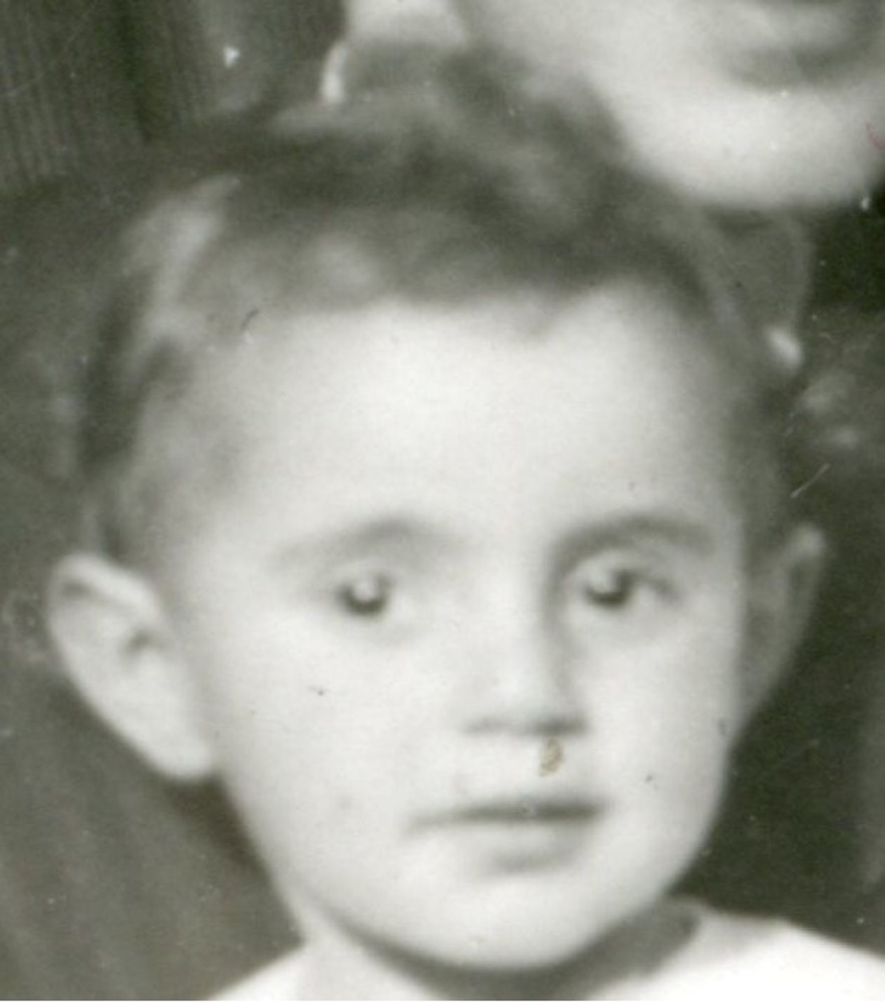 Close-up portrait of a young girl with a neutral expression, shown in a vintage black and white photograph.
