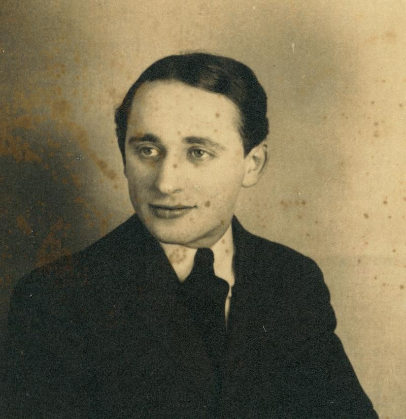 Vintage sepia-toned portrait of a man, featuring a thoughtful expression and wearing a dark suit.