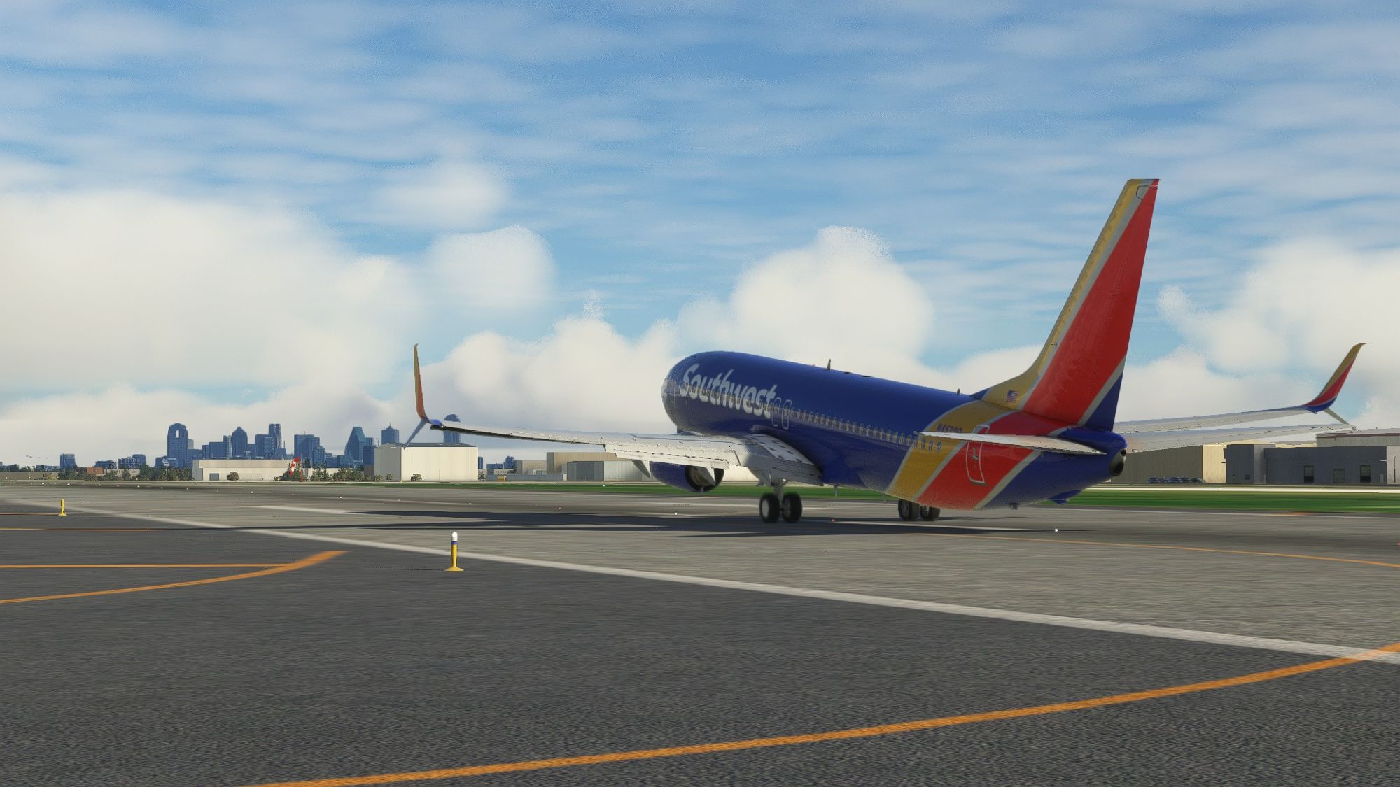 A screenshot from Microsoft Flight Simulator 2020 of a Boeing 737-800, wearing a blue Southwest Airlines livery, with its nose wheel off the ground as it rotates to take flight from Love Field in Dallas, TX. Downtown Dallas can be seen in the background.