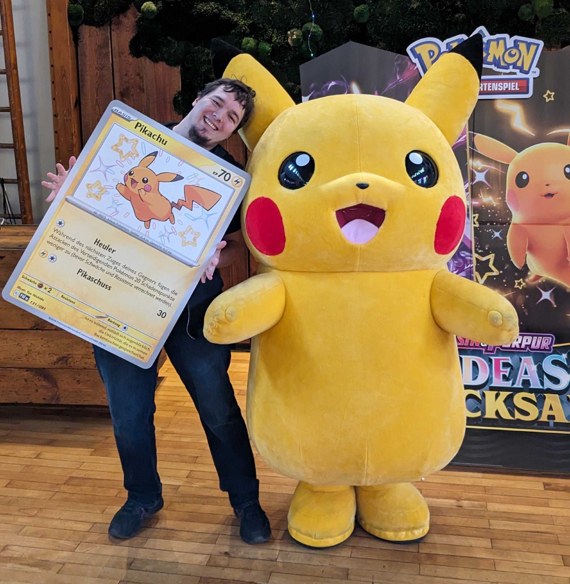 Me holding a huge shiny Pikachu card standing next to a Pikachu | 🎴🃏