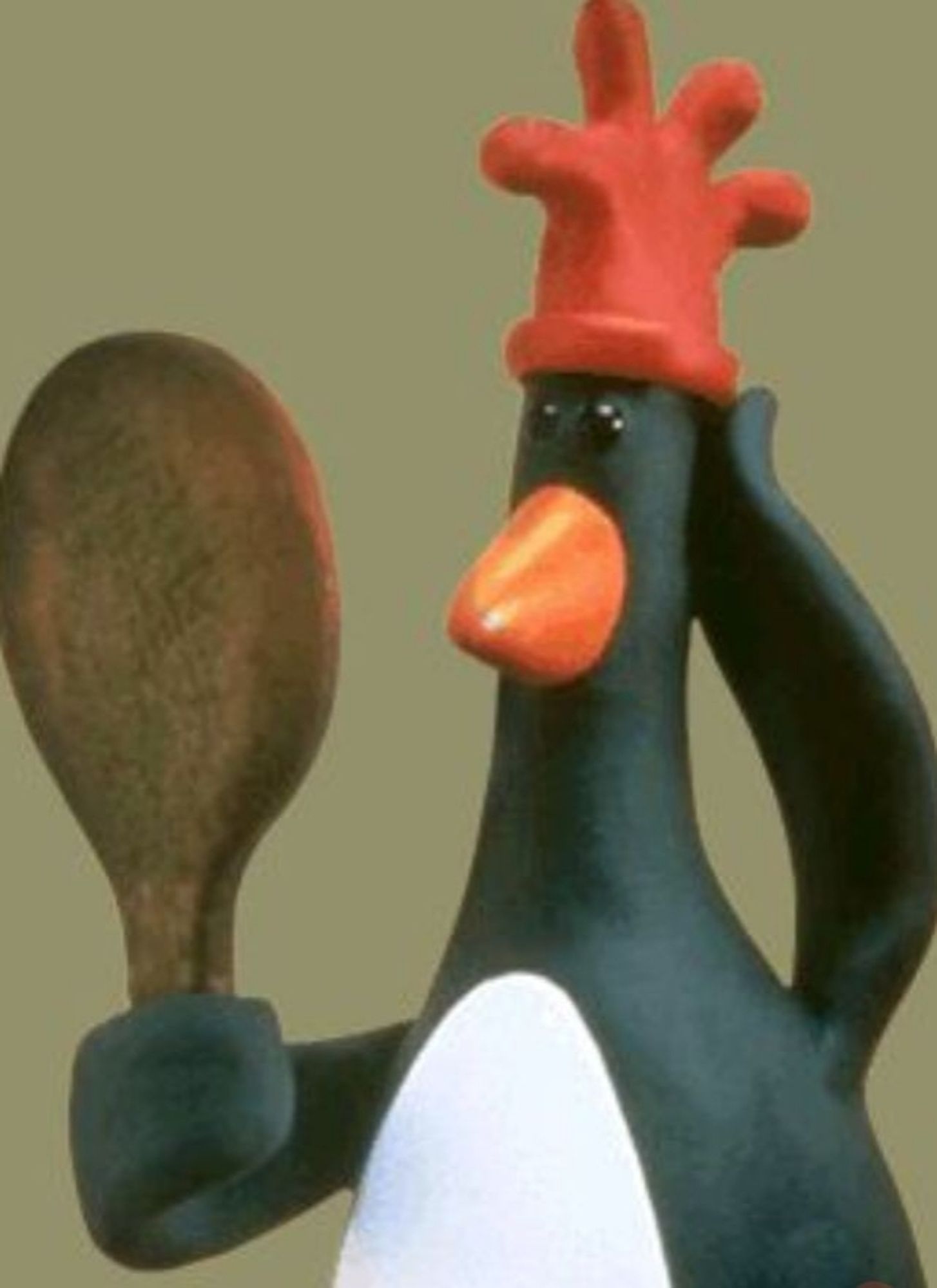 Claymation penguin peering into a hand mirror