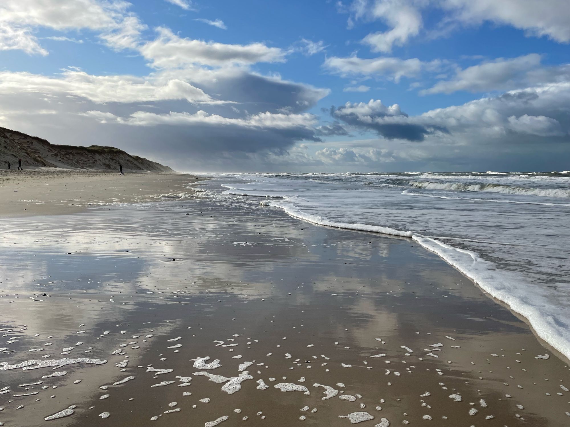 Blick auf das Meer.
Der blaue Himmel spiegelt sich im herangespülten  Wasser.