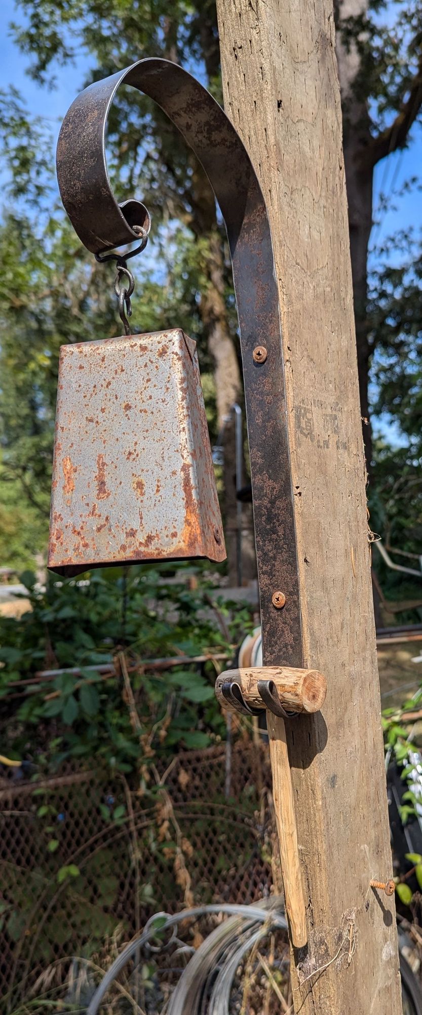 Hand-made cowbell on hanger, with mallet