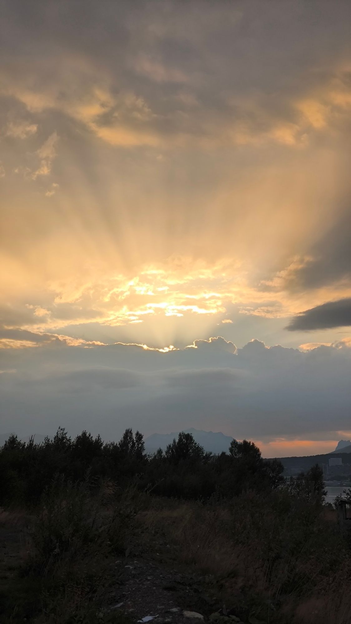 Wolken,  dahinter versteckt die Sonne, zu sehen sind nur die Sonnenstrahlen