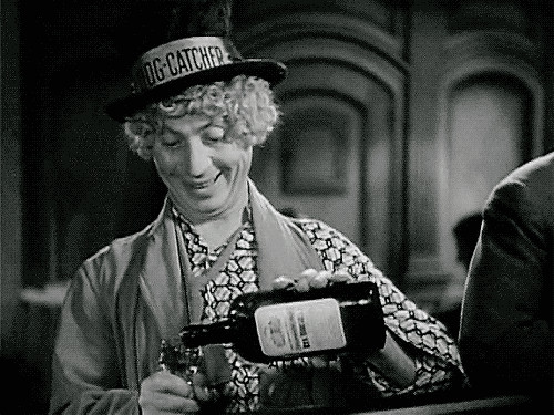 Harpo Marx with a bottle of whisky.