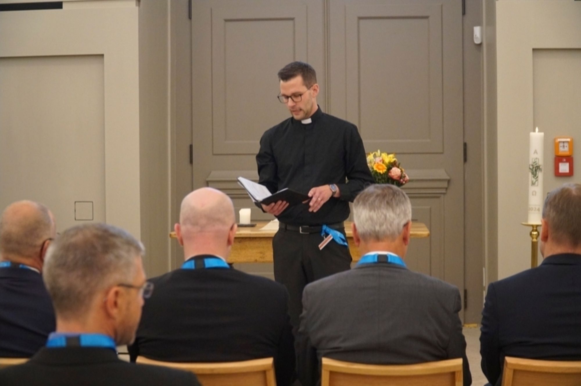 Der Pfarrer der Garnisonkirche vor dem originalen Feldaltar trägt ewas vor aus dem Gebetsbuch