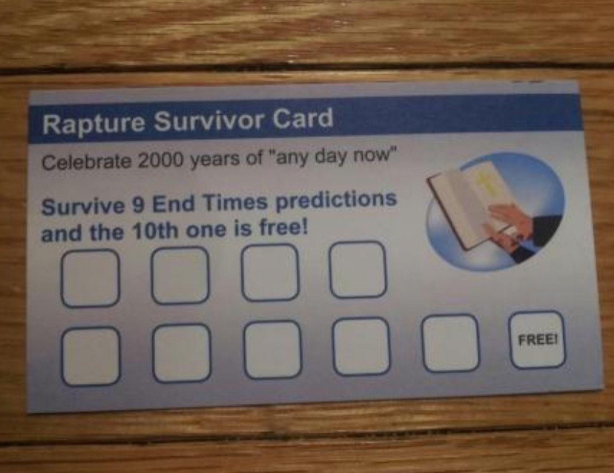 A "Rapture Survivor Card", with a small pic of hands holding a book - like a Bible - and 9 blank spaces with a 10th marked "Free!"
It says: 
"Celebrate 2000 years of 'any day now'
Survive 9 End Times predictions and the 10th one is free!"