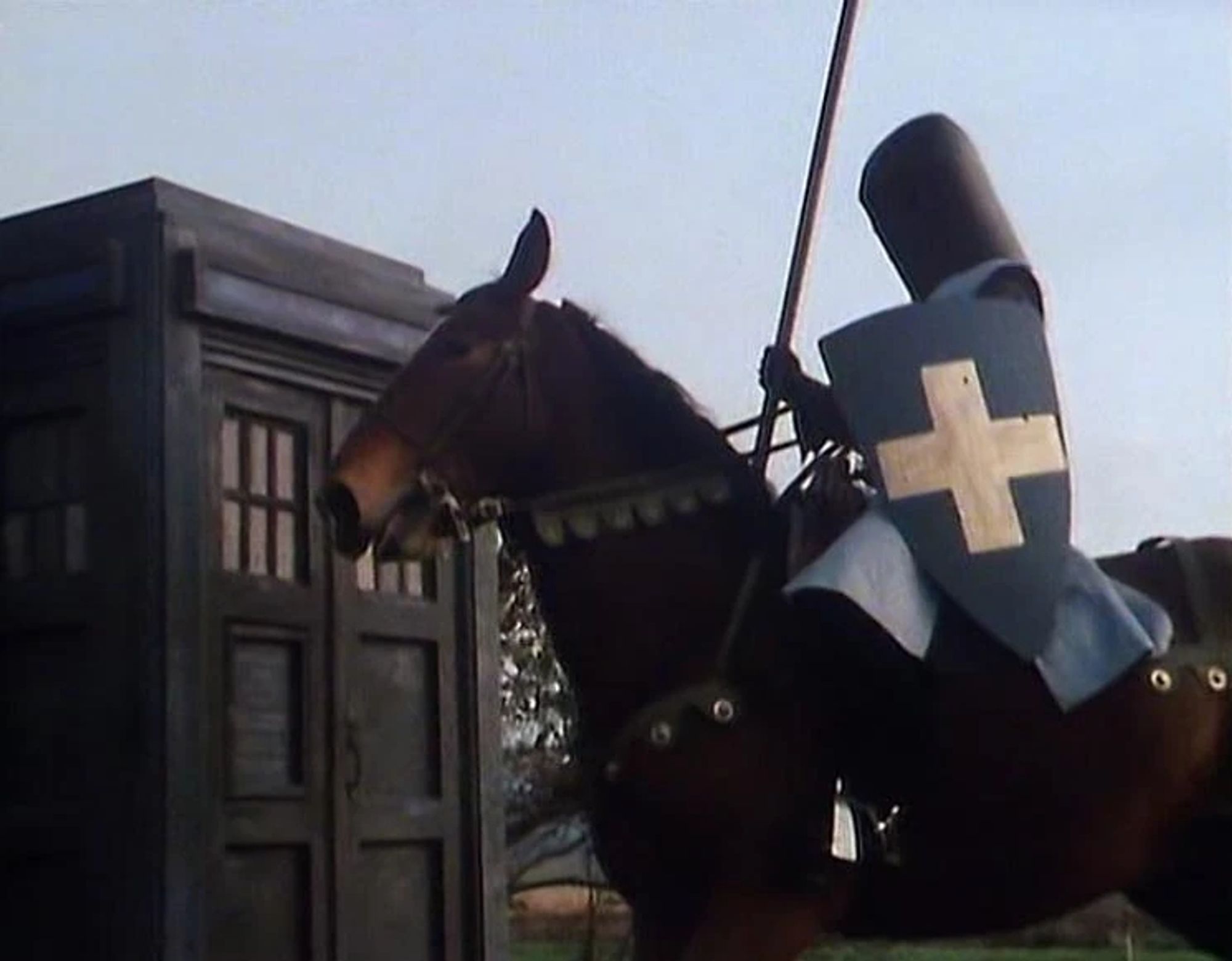 A mediaeval knight on horseback in front of the TARDIS (blue police box).