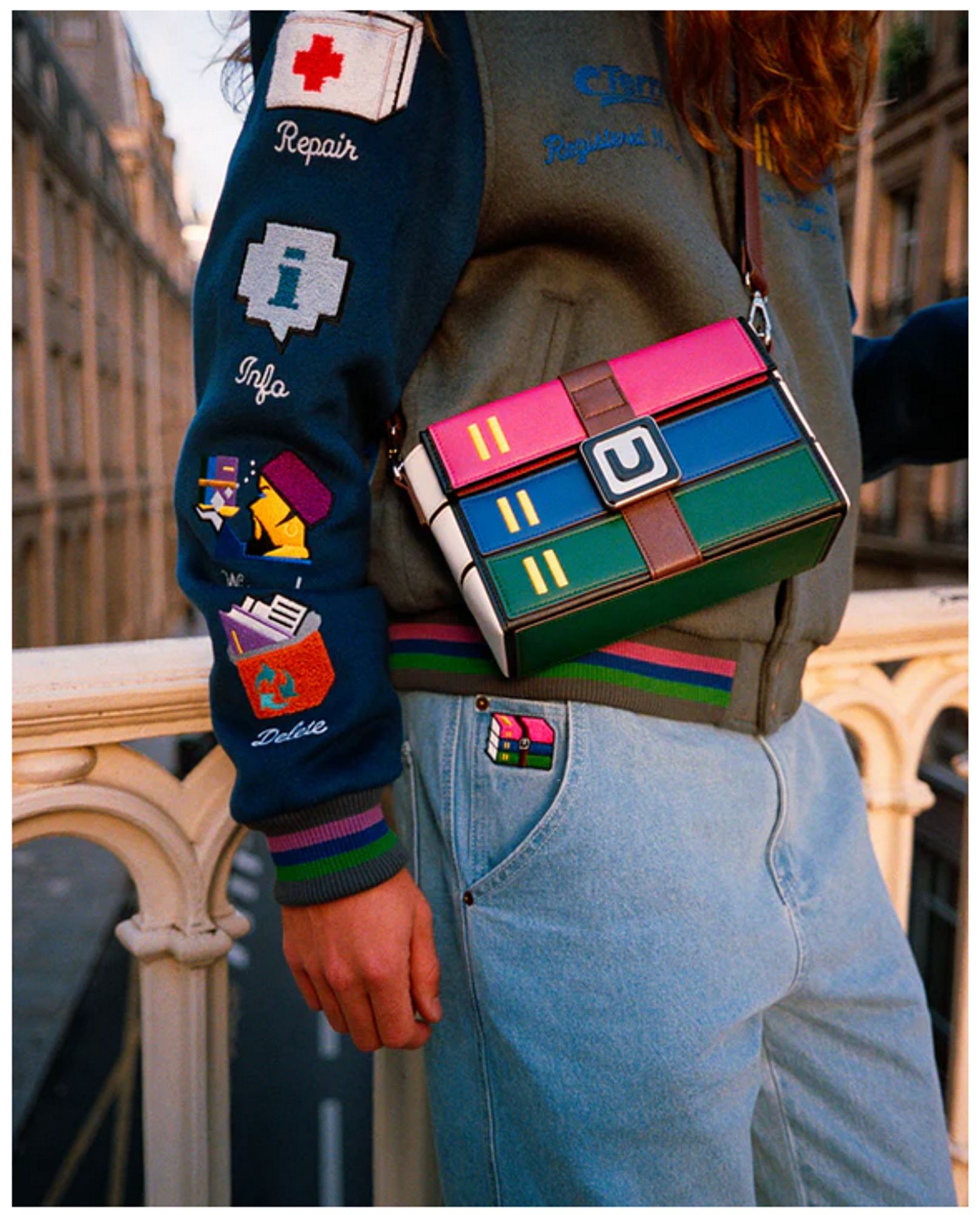 photo of a person wearing a messenger bag/satchel that looks like the winrar logo: three books (purple, blue, and green) stacked and secured with a leather belt