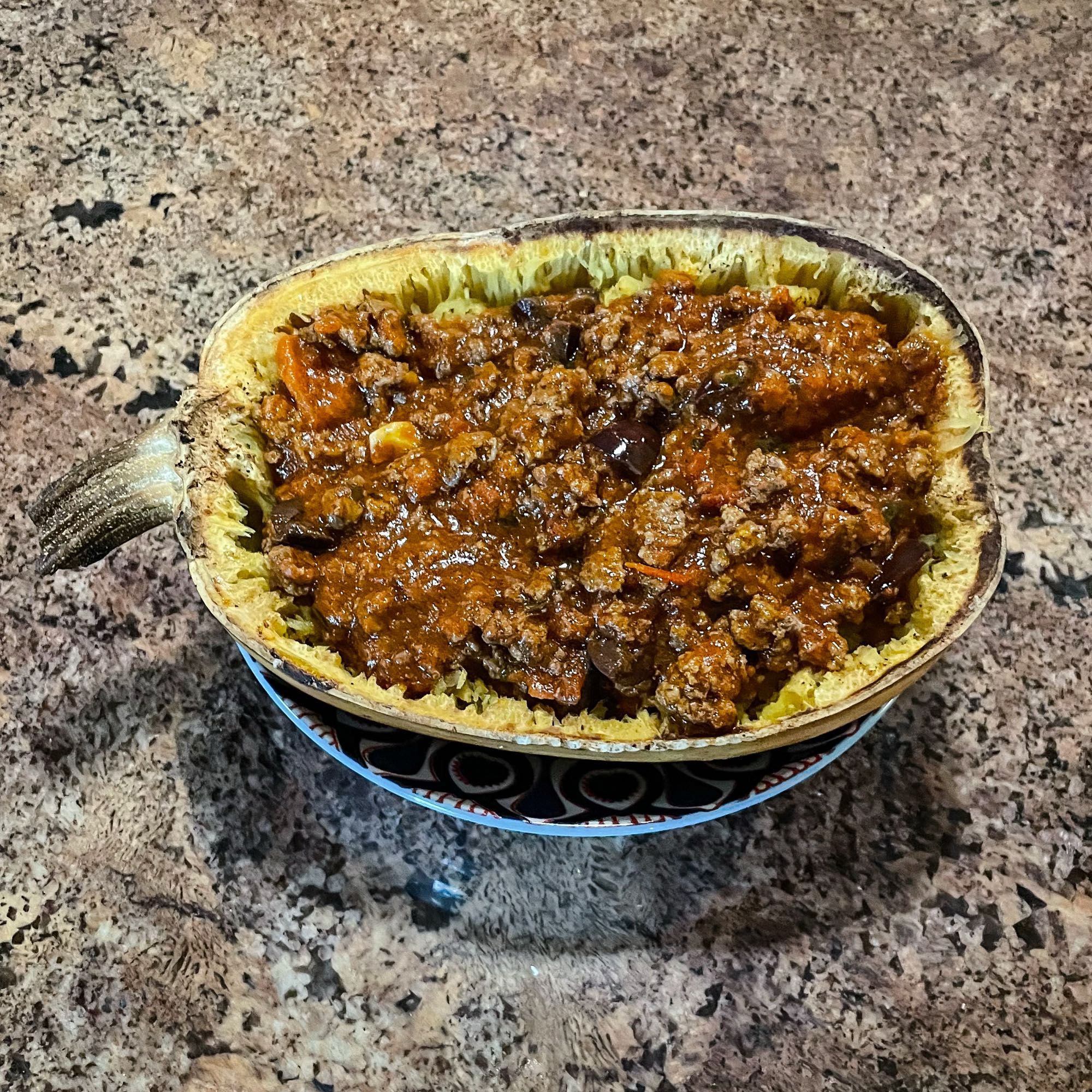 Half of a spaghetti squash filled with a tomato-based meat sauce