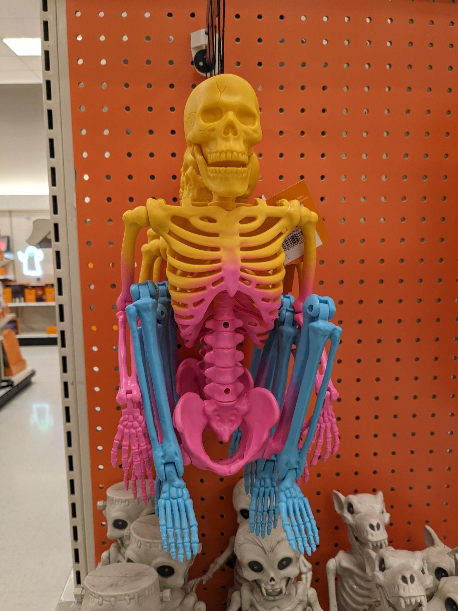 Photo of a plastic yellow, pink and blue toy skeleton on a store shelf